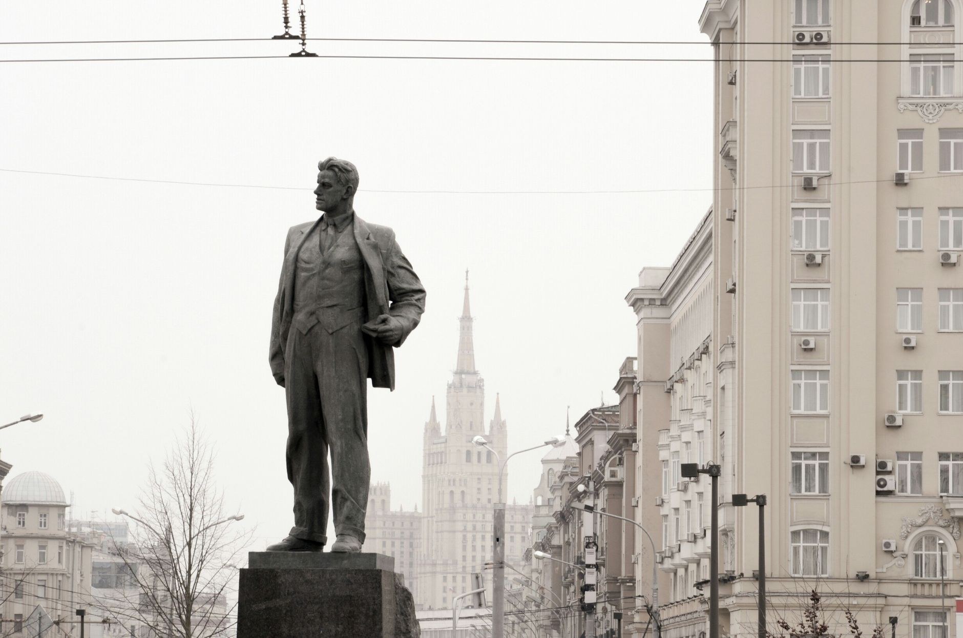 A monumental bronze statue of Lenin standing before the Brutalist Supreme Soviet government building in Tiraspol