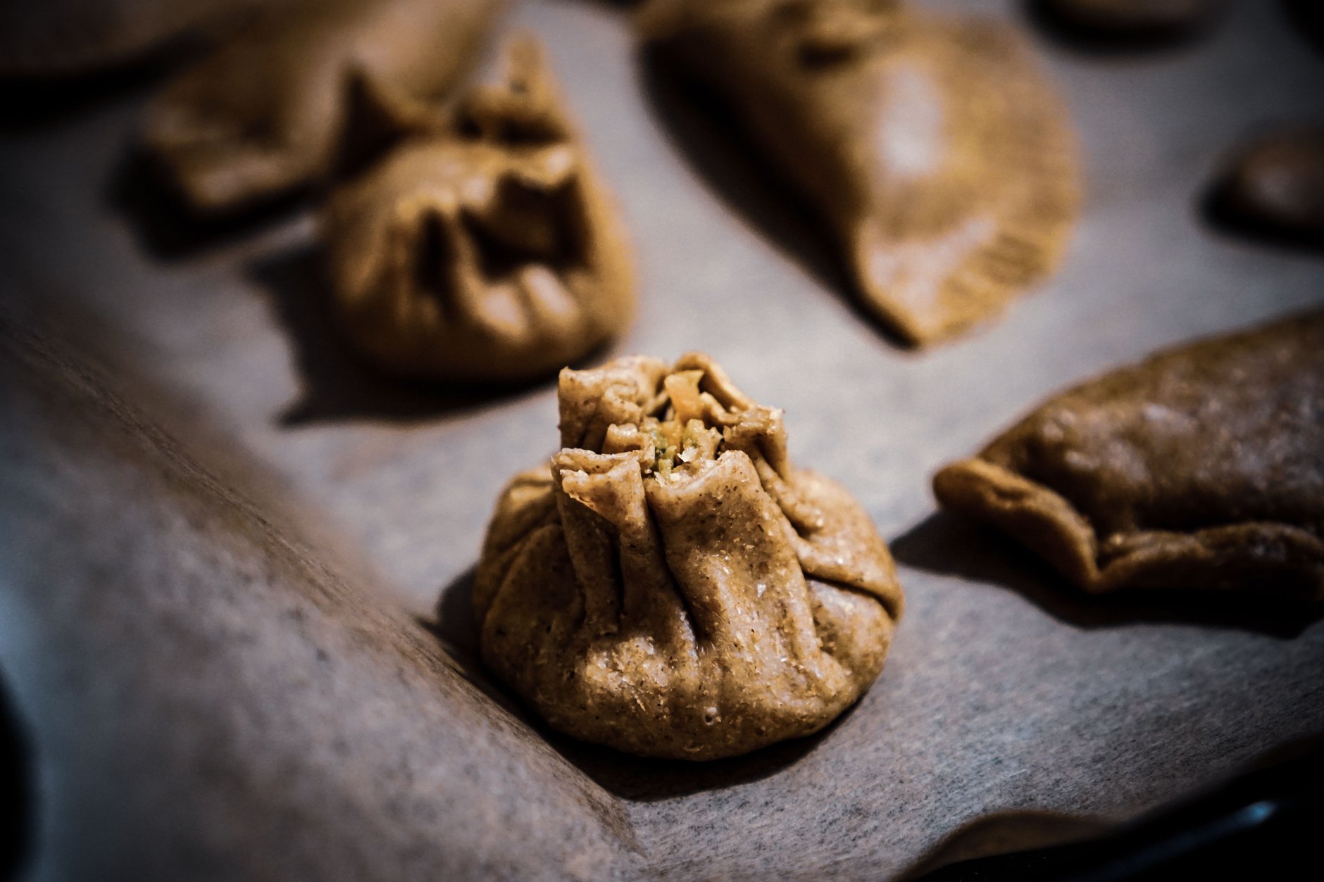 Steaming bamboo basket of freshly pinched Mongolian buuz dumplings stuffed with minced spiced mutton and savory broth