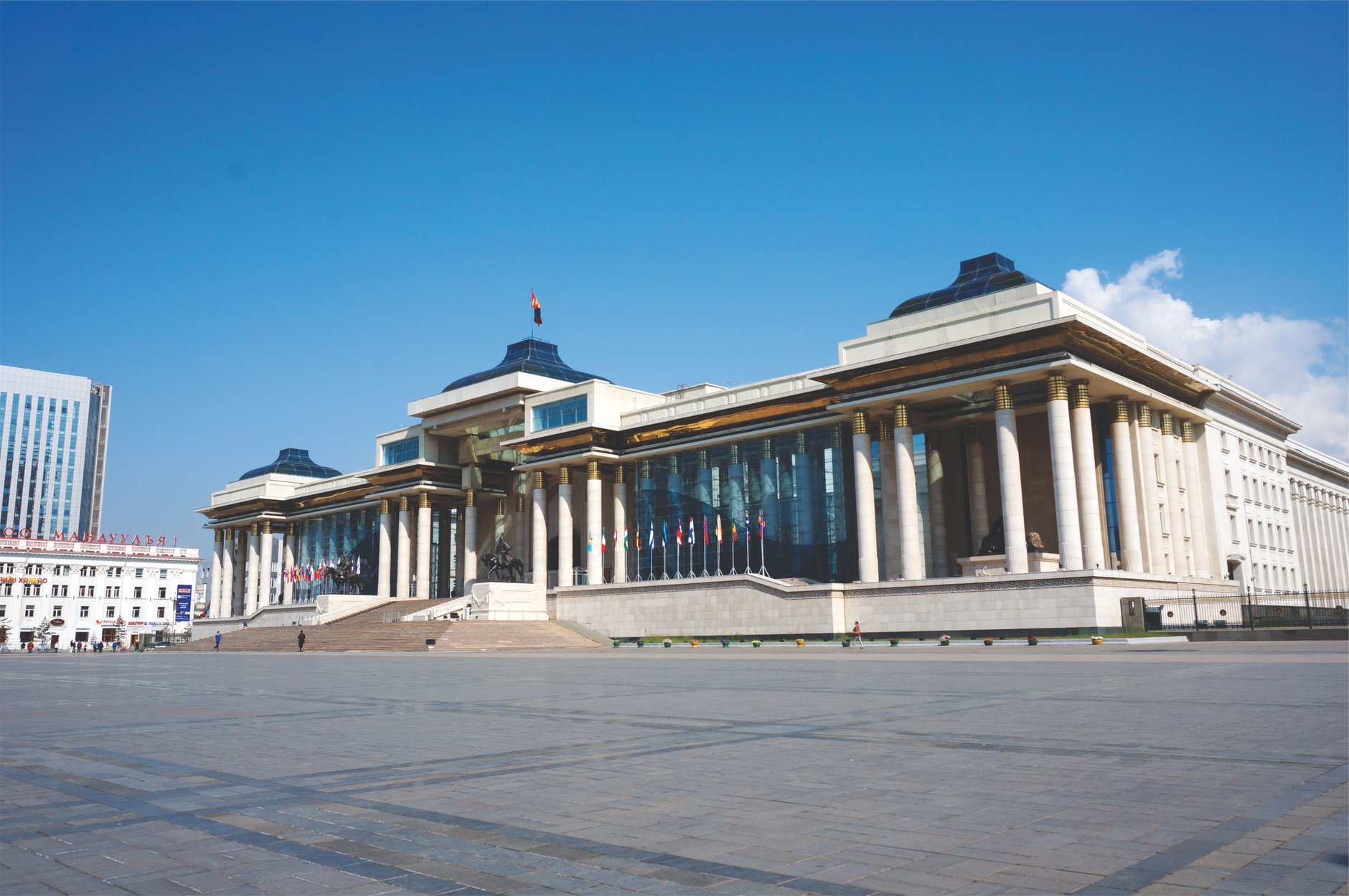 Expansive paved Sukhbaatar Square in central Ulaanbaatar with the colonnaded Government Palace and seated bronze Genghis Khan monument