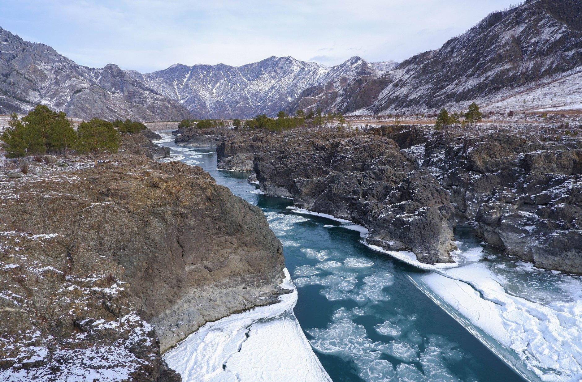 Narrow shaded rocky canyon of Yolyn Am with sheer basalt cliffs sheltering thick winter ice deep into summer
