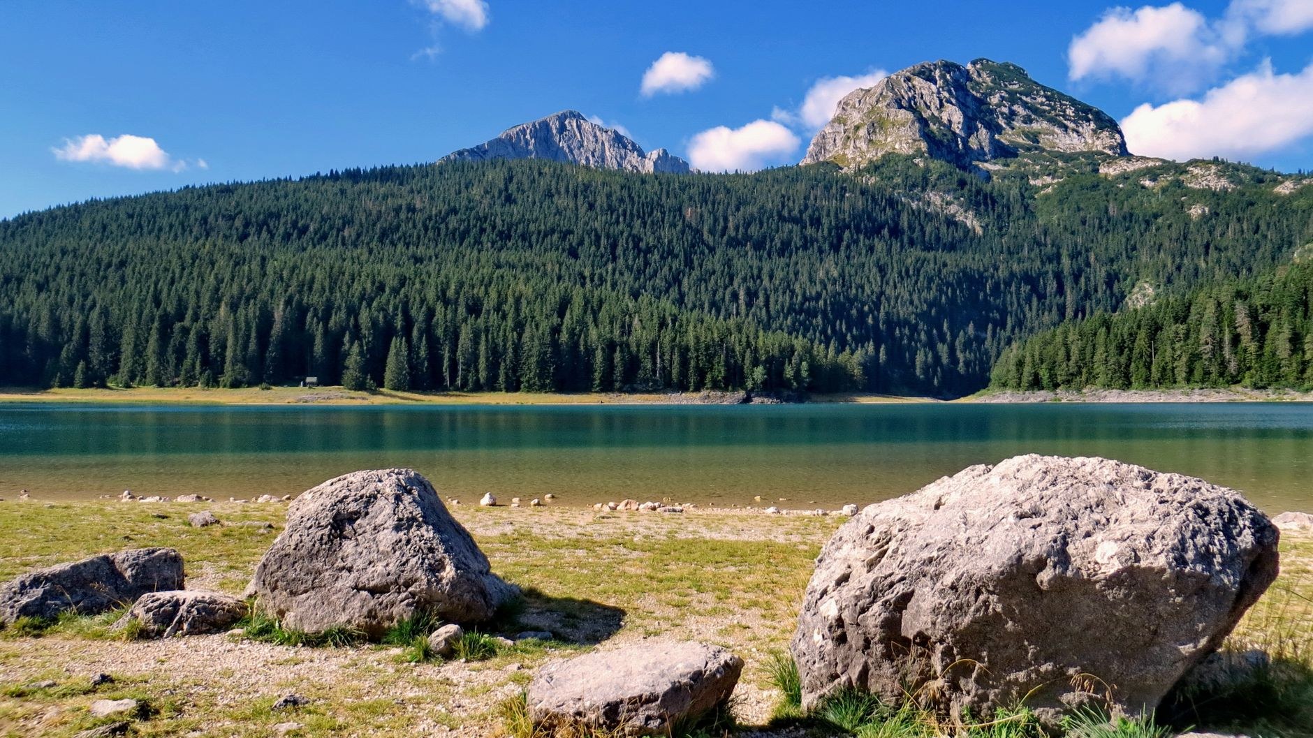 Glacial waters of Black Lake reflecting the rugged limestone crags of Mount Medjed inside Durmitor National Park