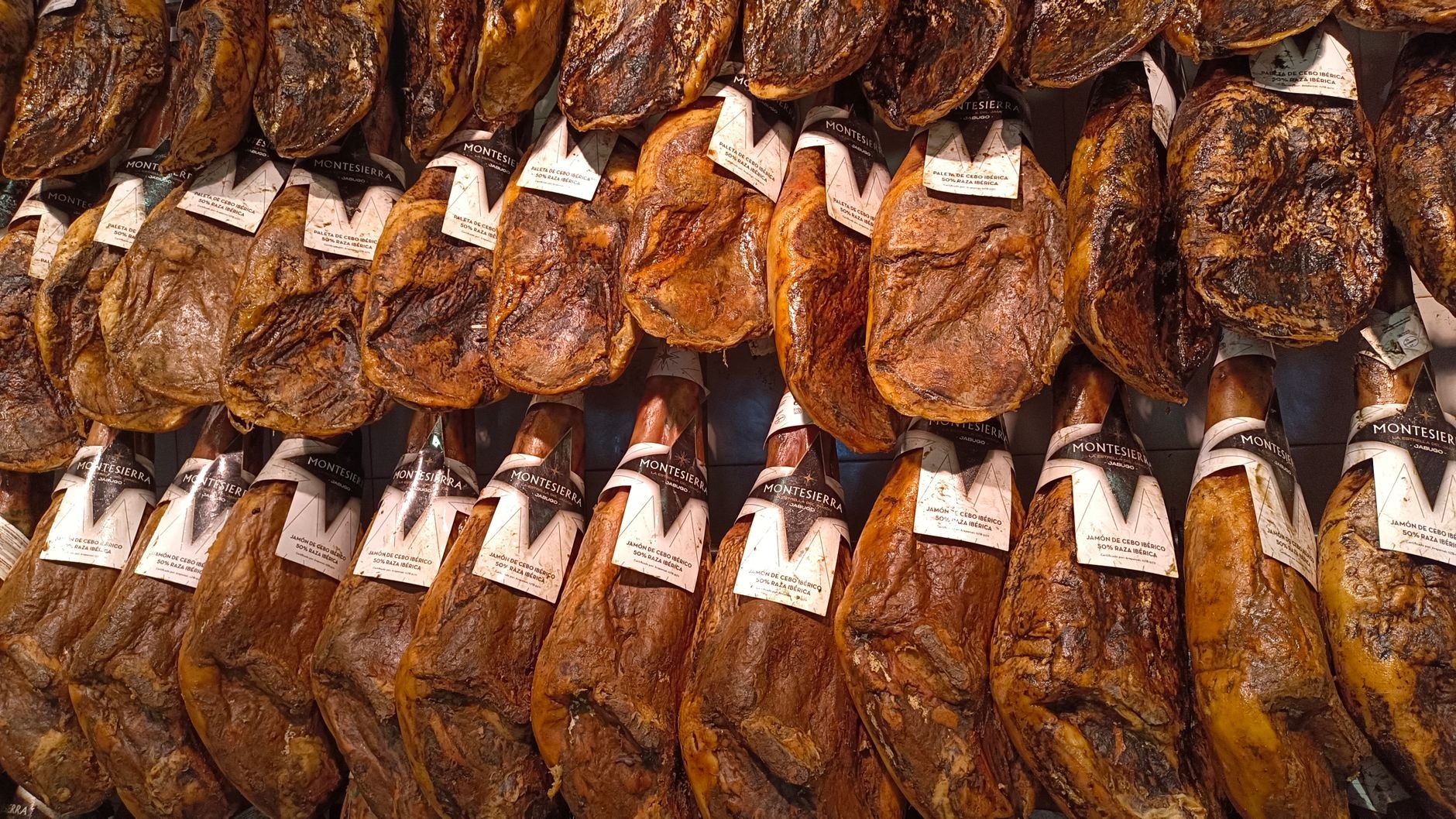 Cured hams hanging in a traditional stone smokehouse in the mountain village of Njeguši, Montenegro