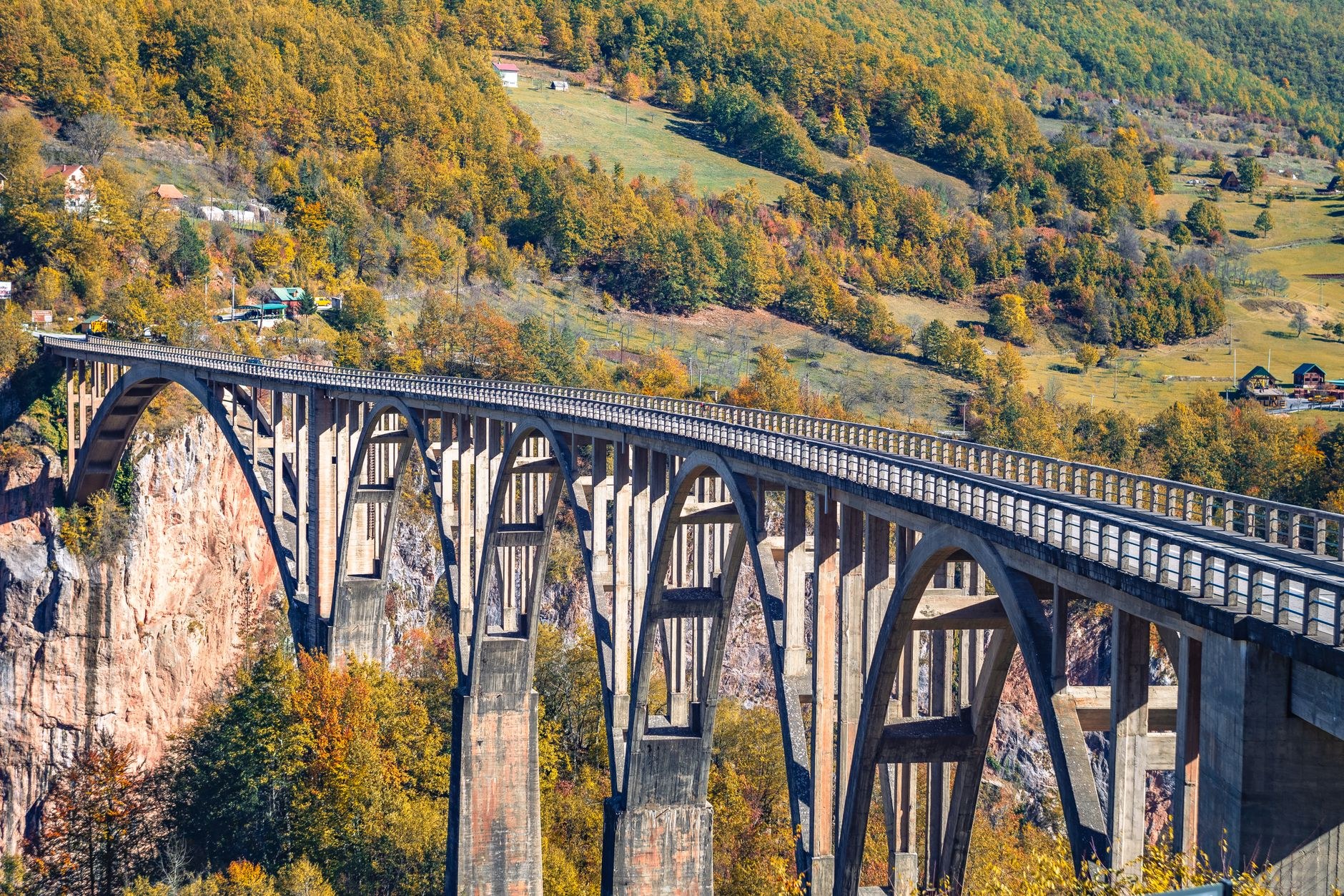 Monumental five-arch concrete span of Đurđevića Tara Bridge towering high above the emerald Tara River Canyon in Montenegro