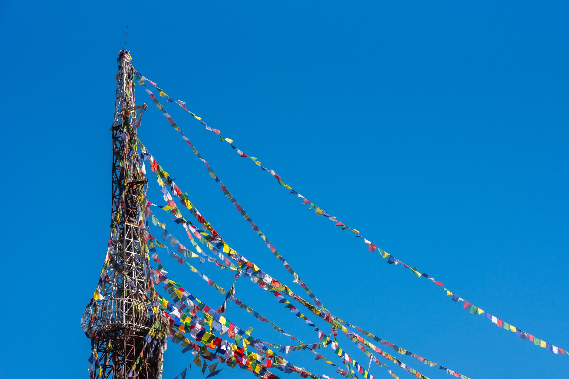 Vibrant Tibetan Buddhist prayer flags fluttering in the mountain wind along a high Himalayan ridge