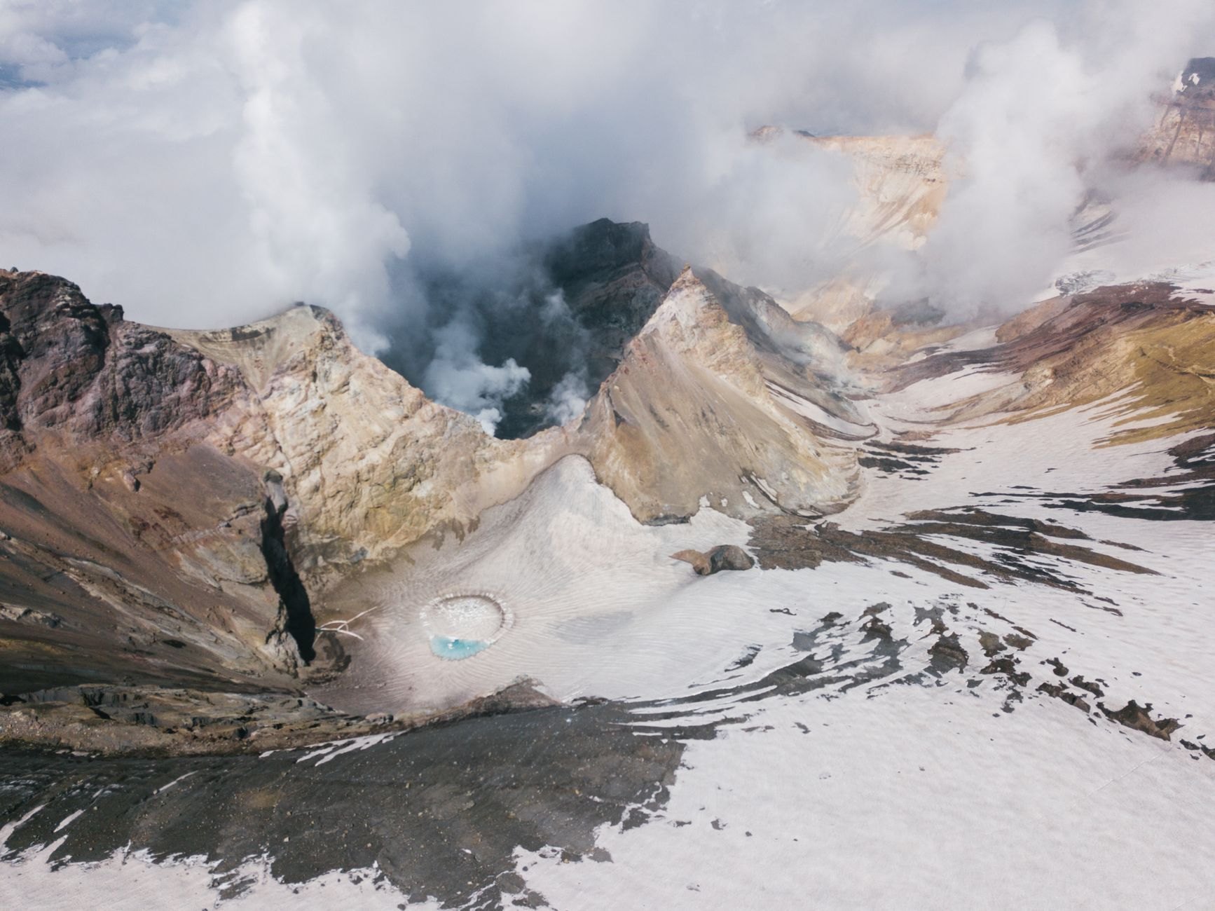 Sulfur steam and smoke plumes billowing from the rugged caldera walls of active Santiago crater at Masaya Volcano