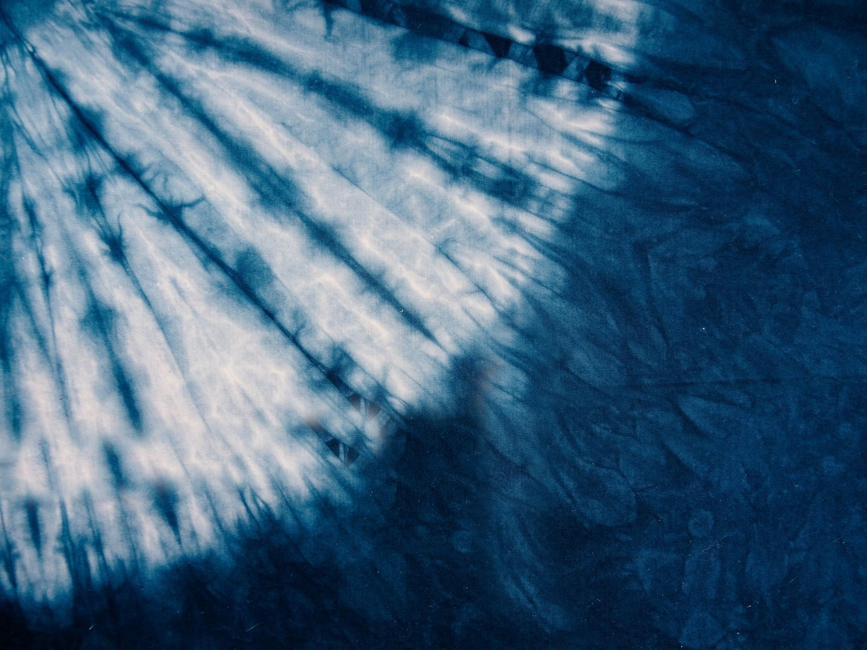 Intricate hand-dyed indigo blue tie-dye textile patterns showcasing traditional Yoruba Adire craftsmanship