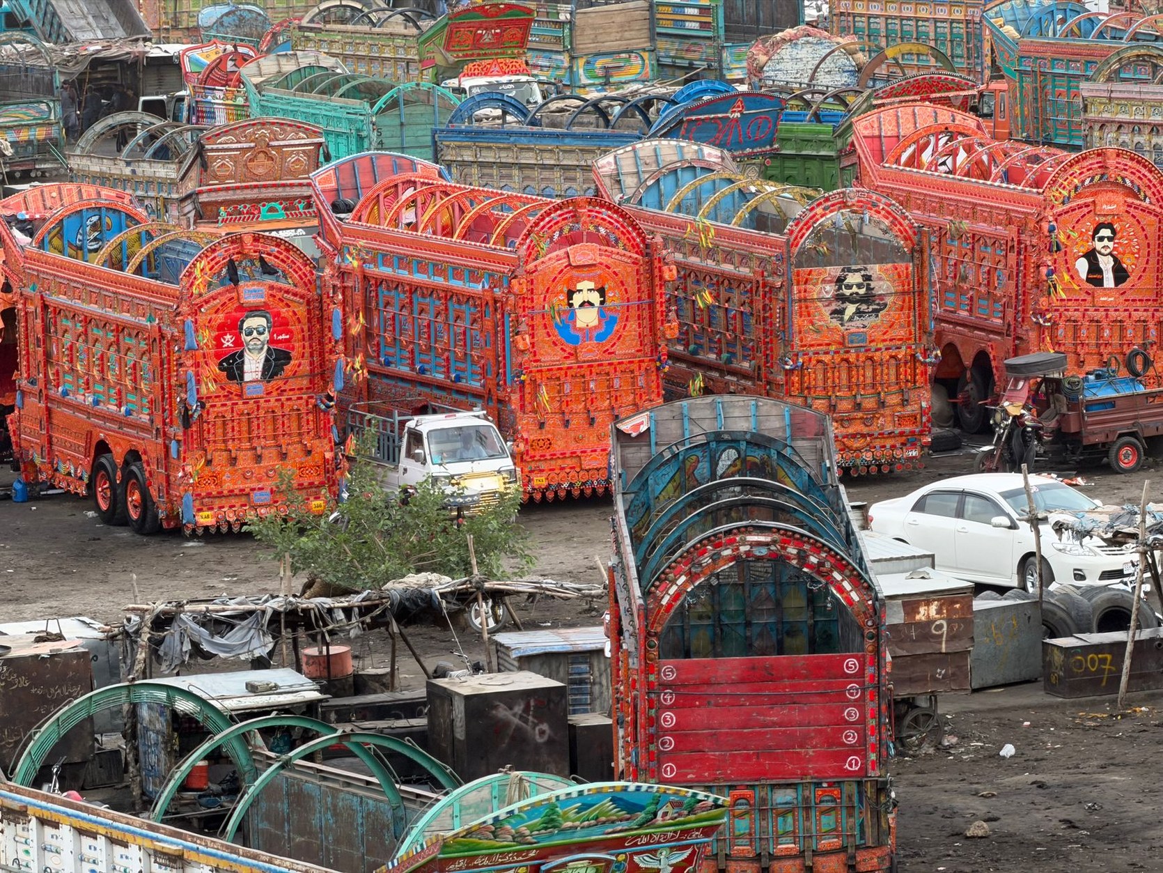 Intricately hand-painted floral motifs, reflective kaleidoscope glasswork, and steel repousse on a traditional Pakistani truck