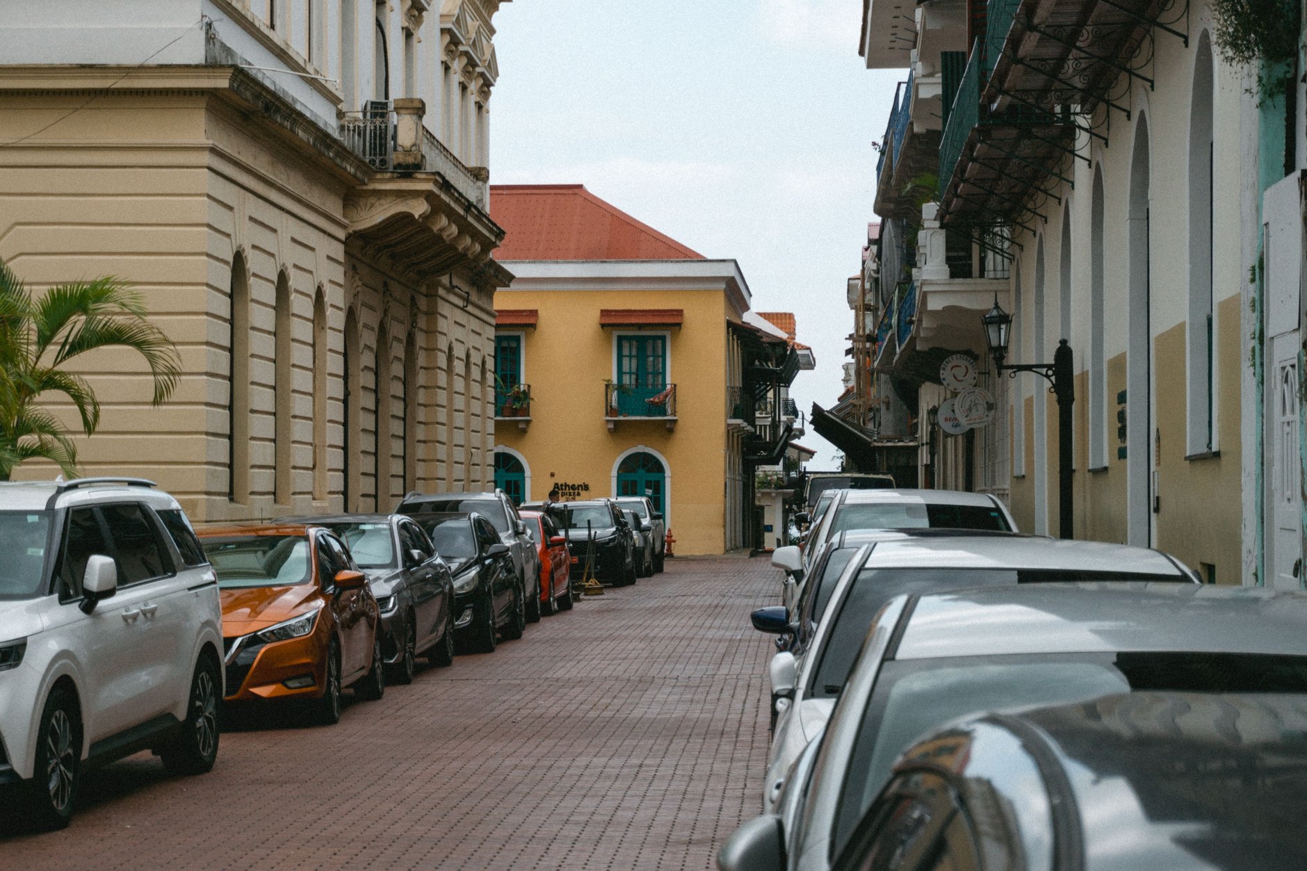Cobblestone street lined with restored pastel French and Spanish colonial buildings with wrought-iron balconies in Casco Viejo