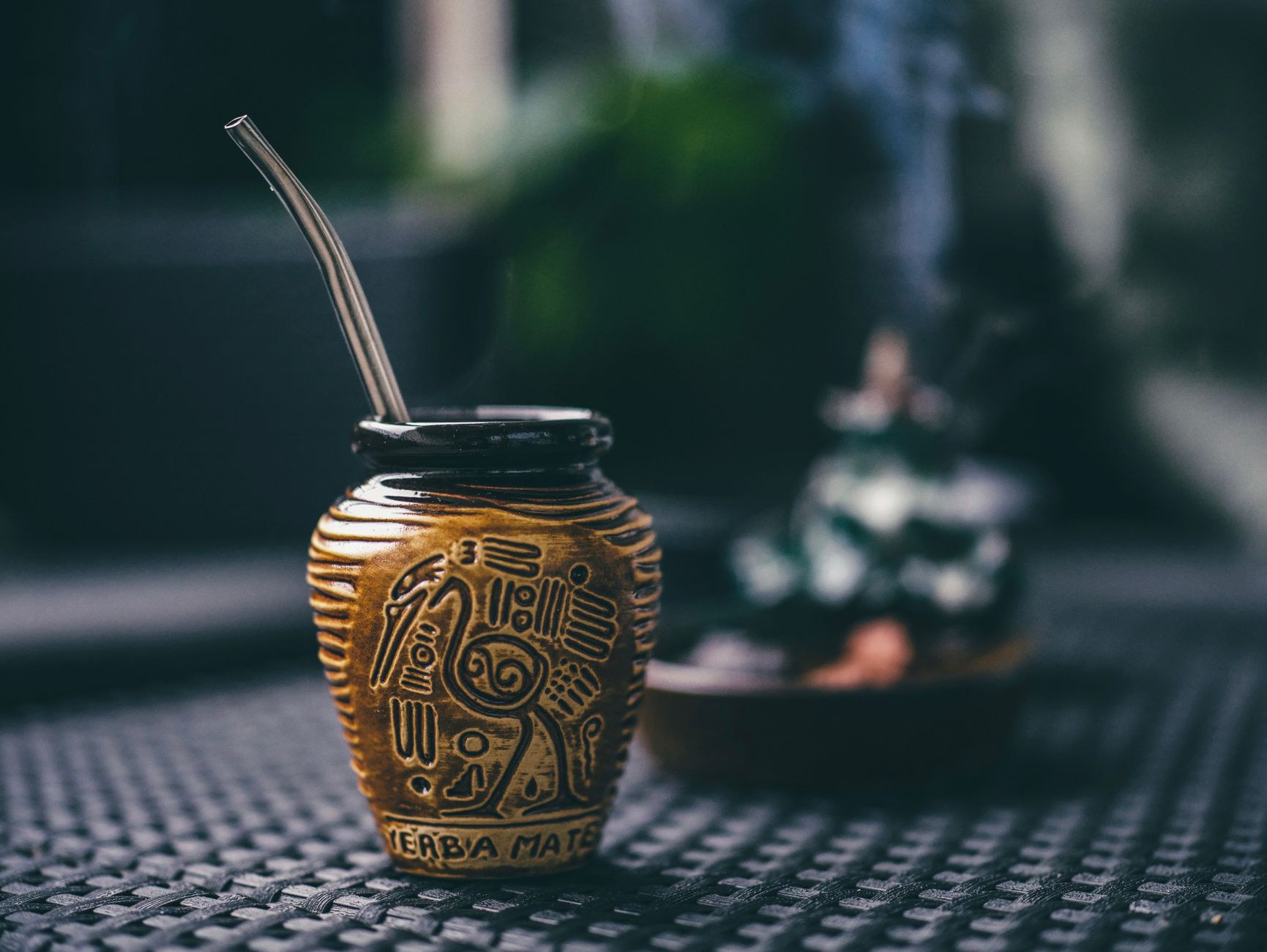 Traditional handcrafted guampa cup filled with cured yerba mate and metal bombilla straw for refreshing cold tereré