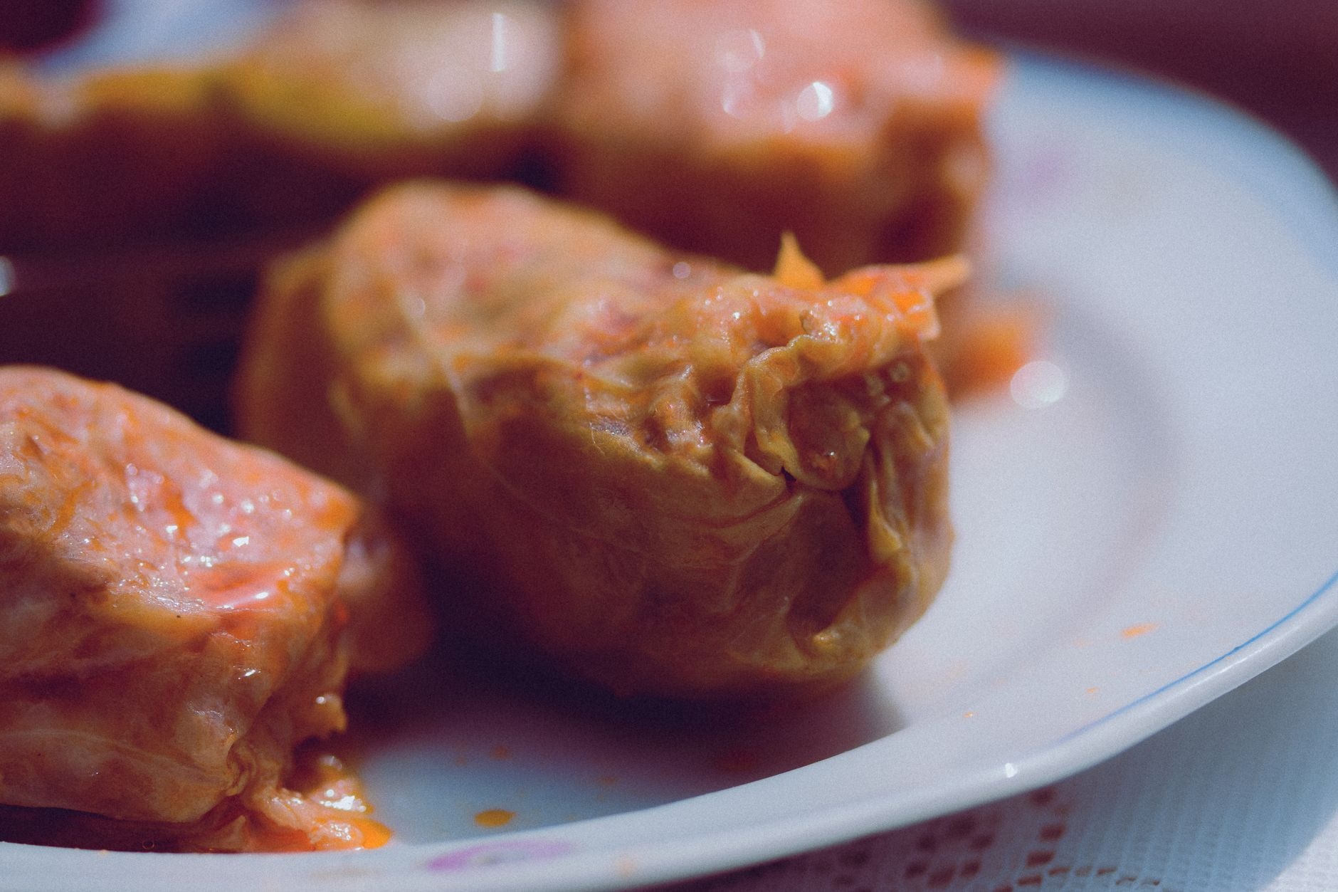 Traditional Romanian sarmale cabbage rolls served with steaming yellow mamaliga polenta, sour cream, and hot chili pepper