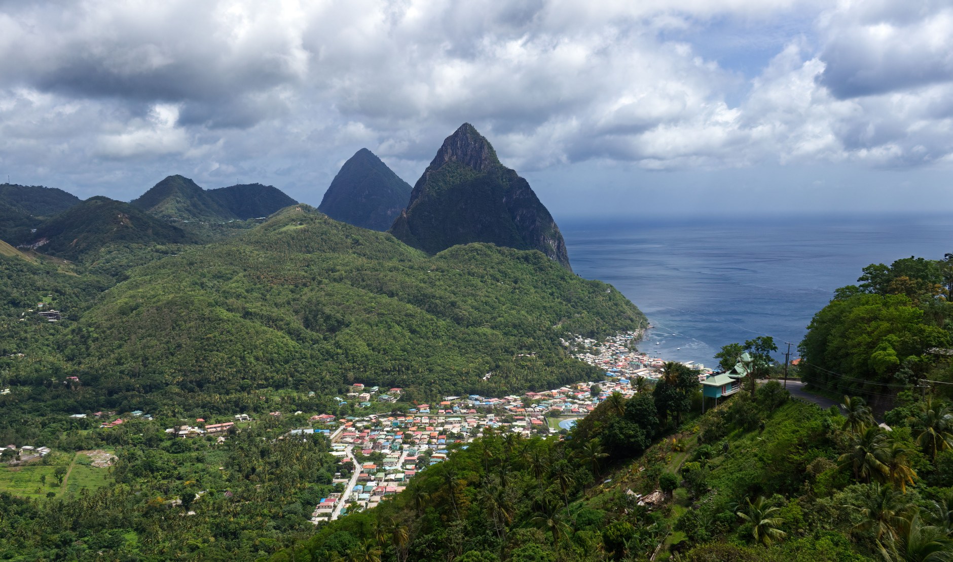 Lush forested mountain slopes and volcanic peaks surrounding the coastal settlement of Soufriere