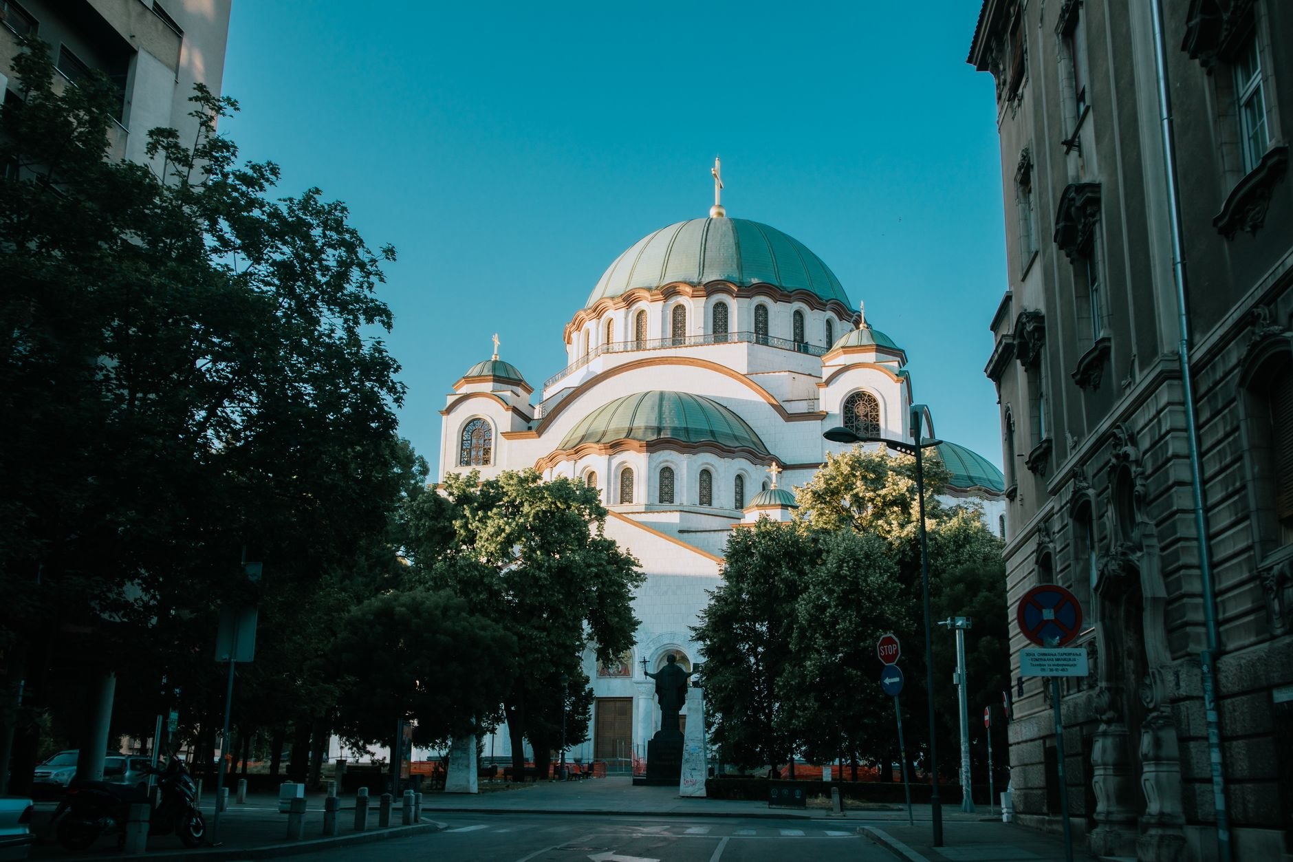Monumental white marble facade and green copper domes of the Orthodox Temple of Saint Sava rising over Vracar plateau in Belgrade
