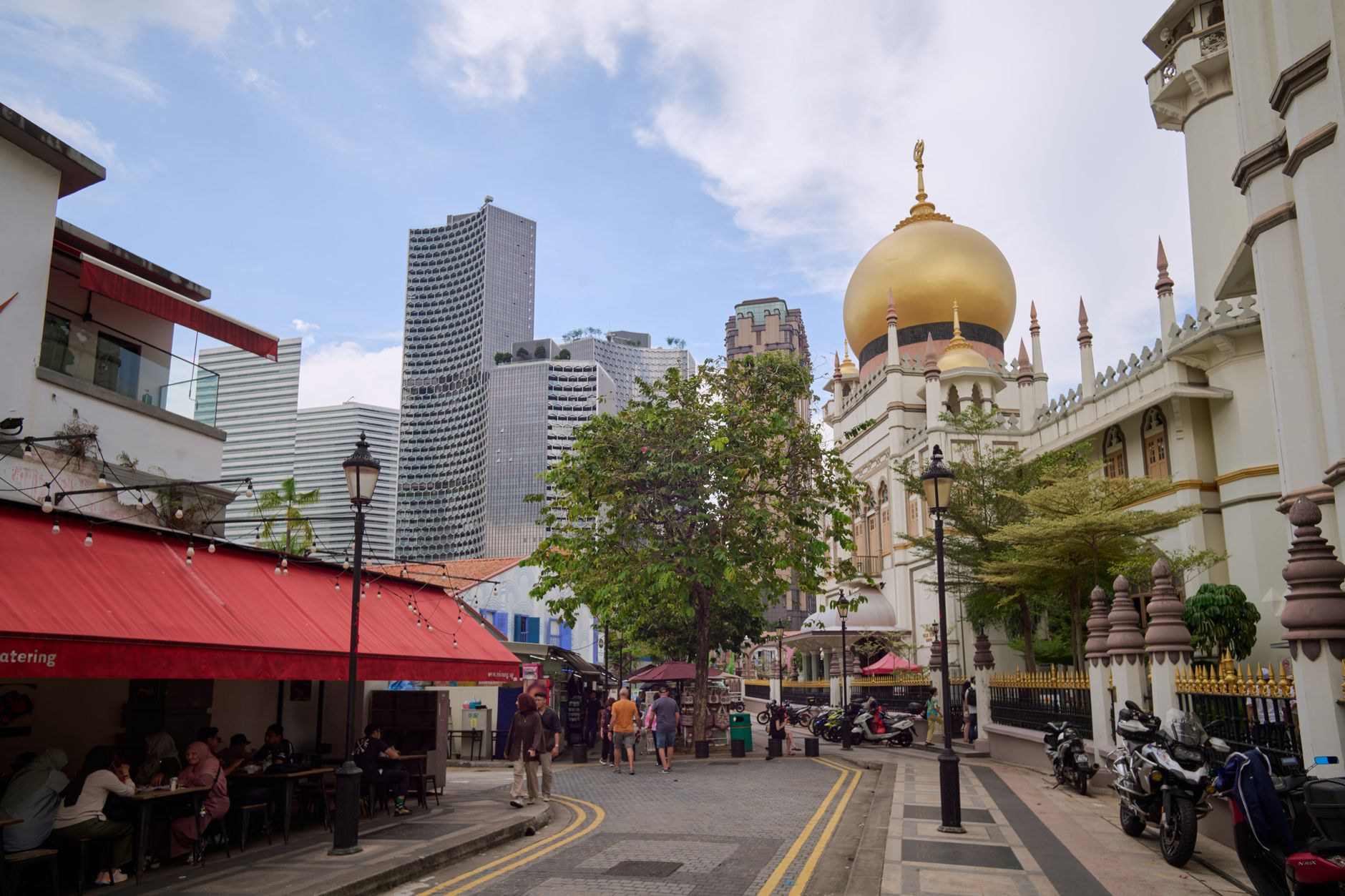 Majestic golden dome of Sultan Mosque framed by palm trees