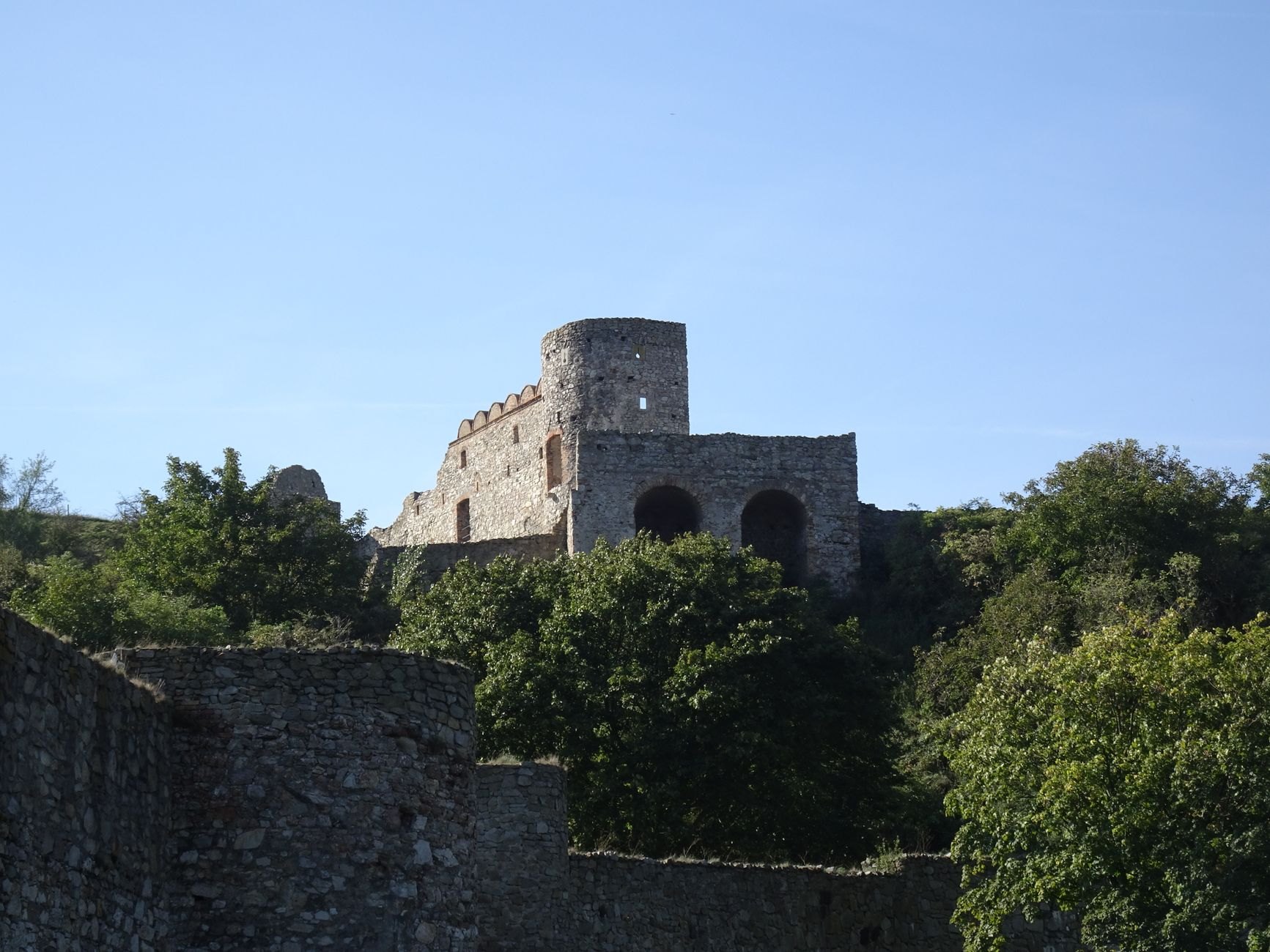 Ancient stone fortress ruins and watchtower perched on a sheer limestone cliff at the confluence of the Danube and Morava rivers