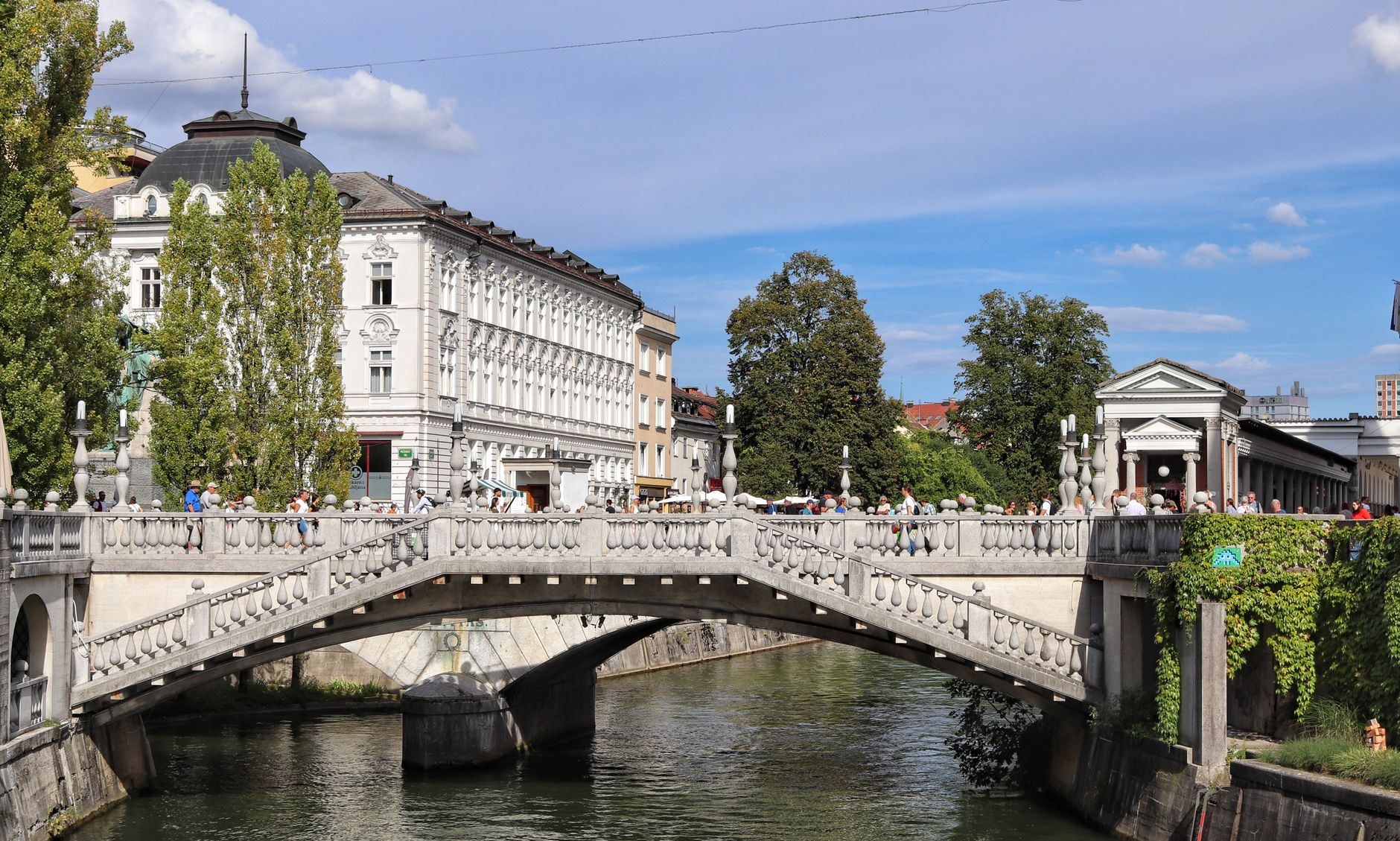 Architect Jože Plečnik's Triple Bridge (Tromostovje) crossing the Ljubljanica River toward medieval Ljubljana Castle