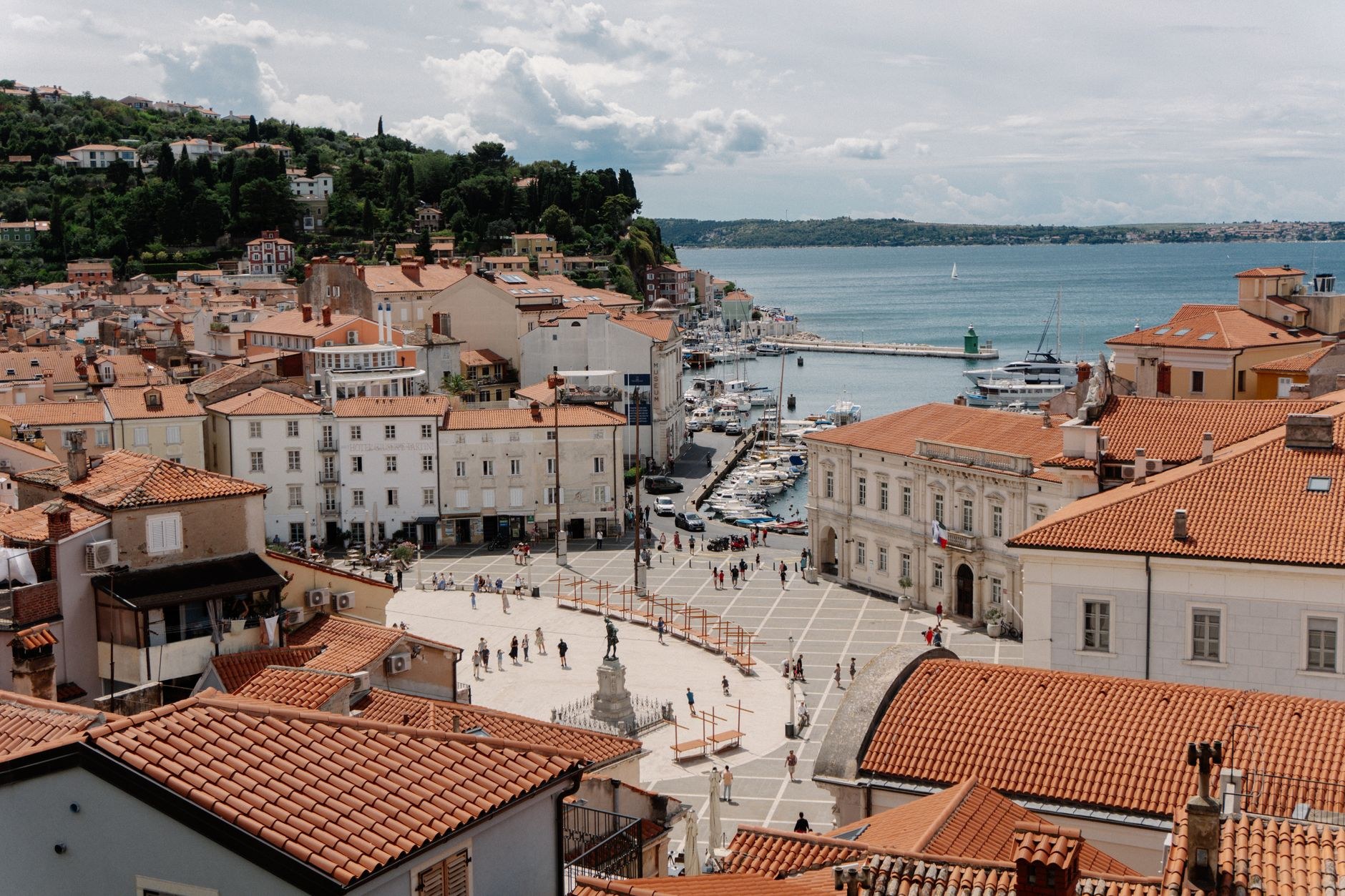 Oval marble paving of Tartini Square surrounded by pastel Venetian Gothic palaces in coastal Piran, Slovenia