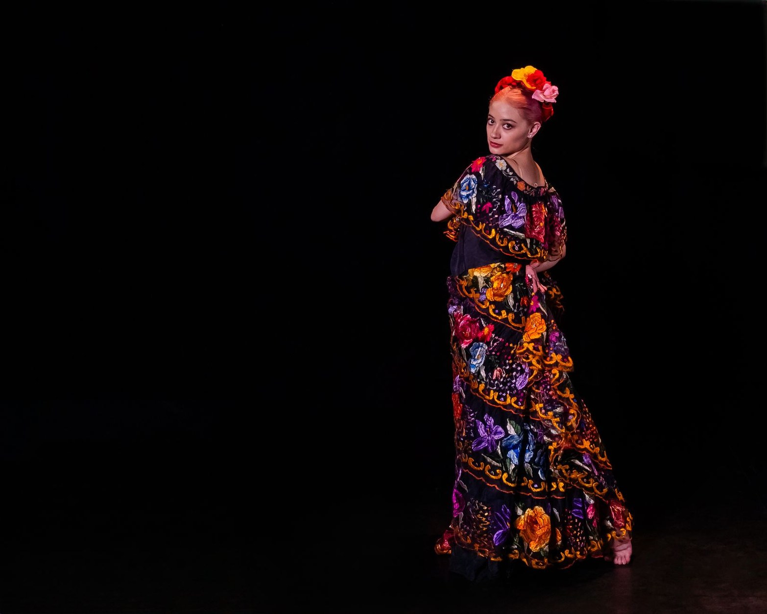 Flamenco dancer in traditional ruffled dress performing expressive footwork
