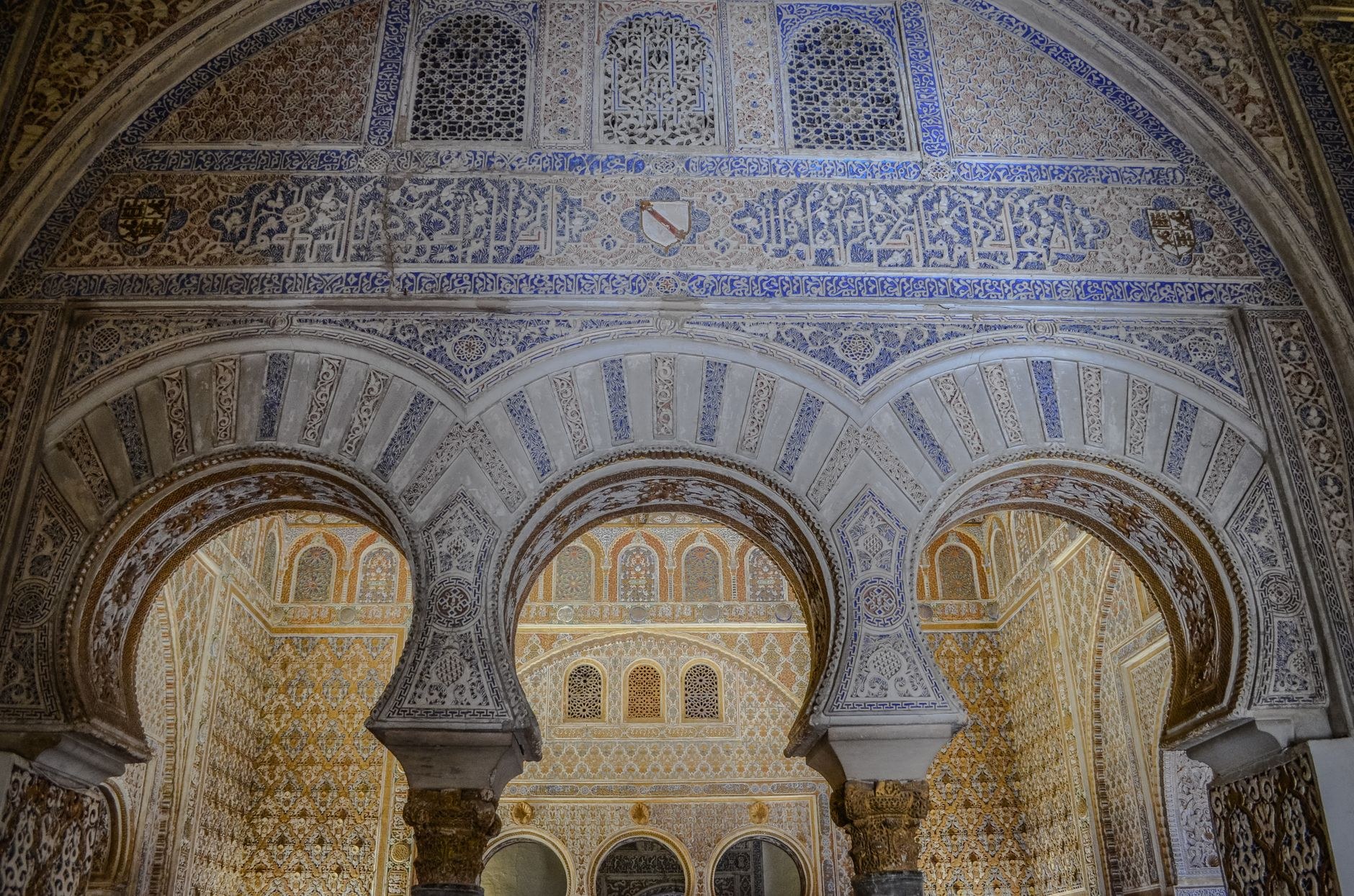 Mudéjar stucco carvings and scalloped arches inside the Real Alcázar of Seville