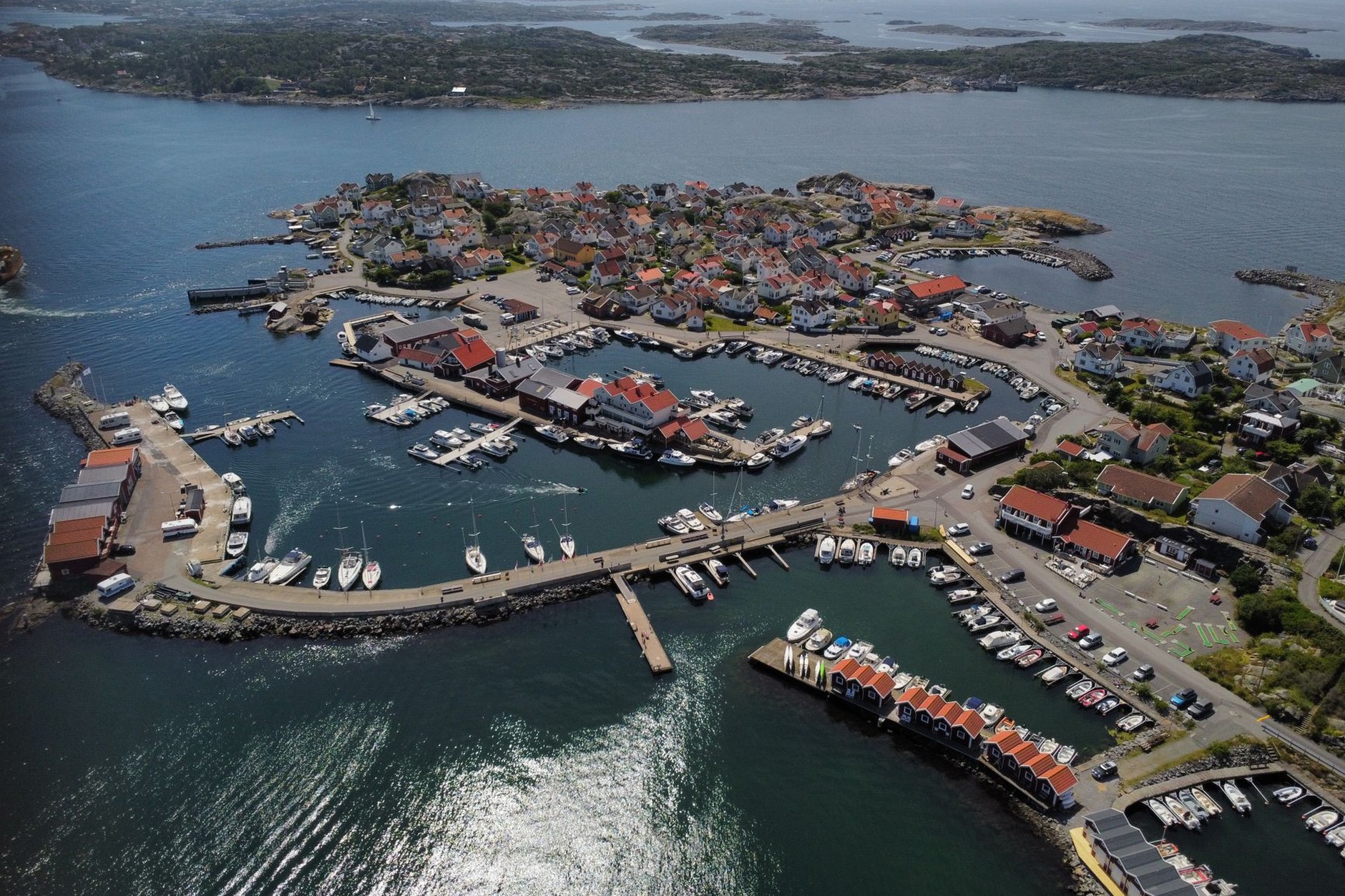 Red timber fishing boathouses and granite sea rocks along the rugged Bohuslän archipelago on Sweden's west coast