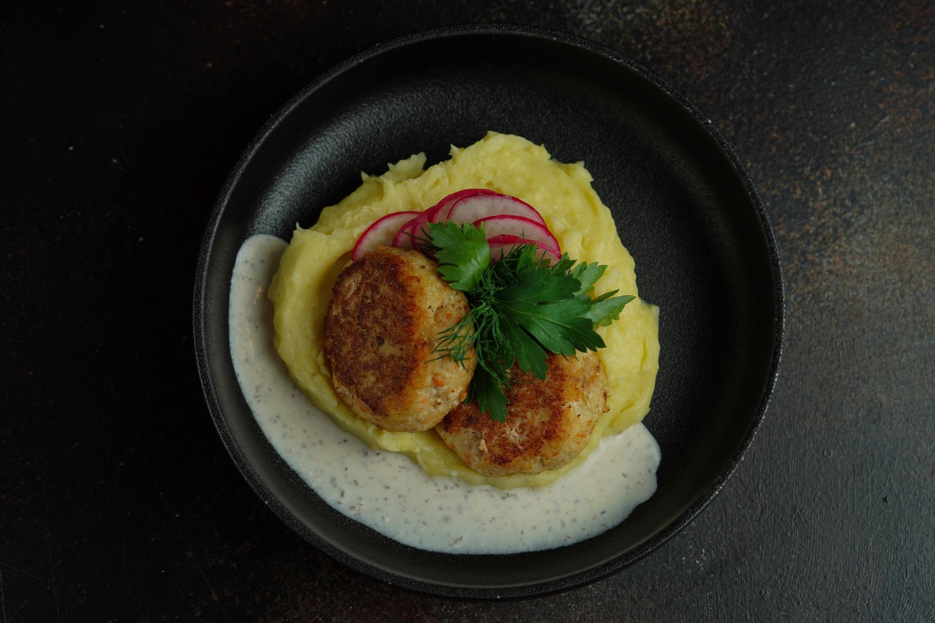 Classic Swedish meatballs served with creamy mashed potatoes, pressed cucumbers, rich brown gravy, and tart lingonberries