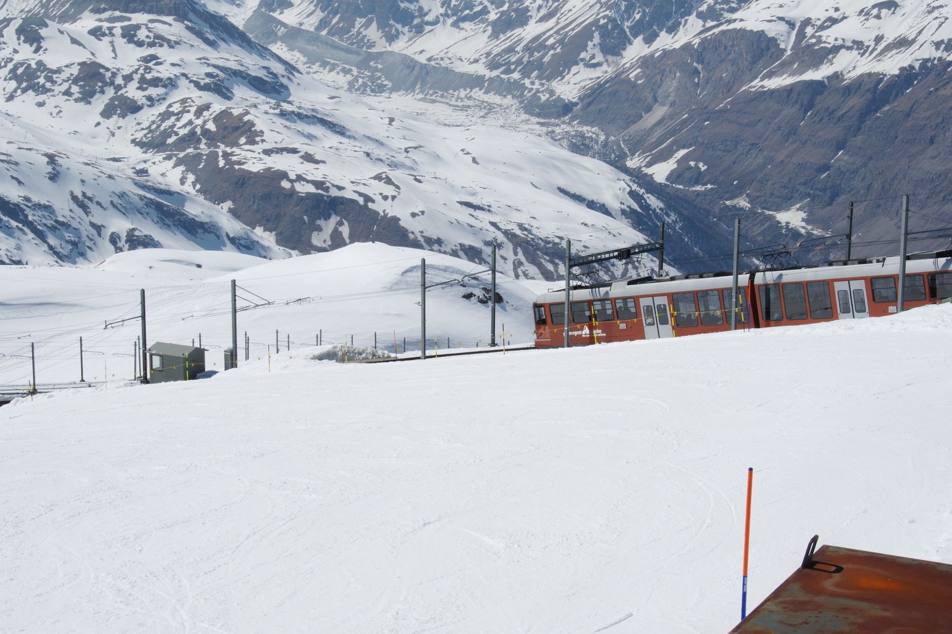 Gornergrat open-air cogwheel train ascending steep mountain tracks with snow-dusted alpine ridges
