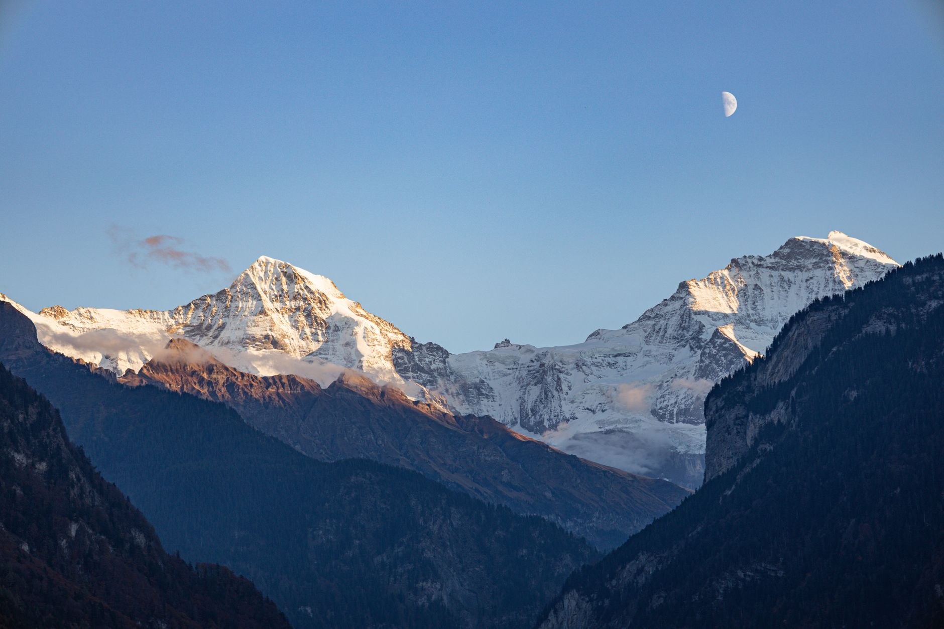Snow-capped peaks and glaciers of the Eiger, Mönch, and Jungfrau massif under blue skies