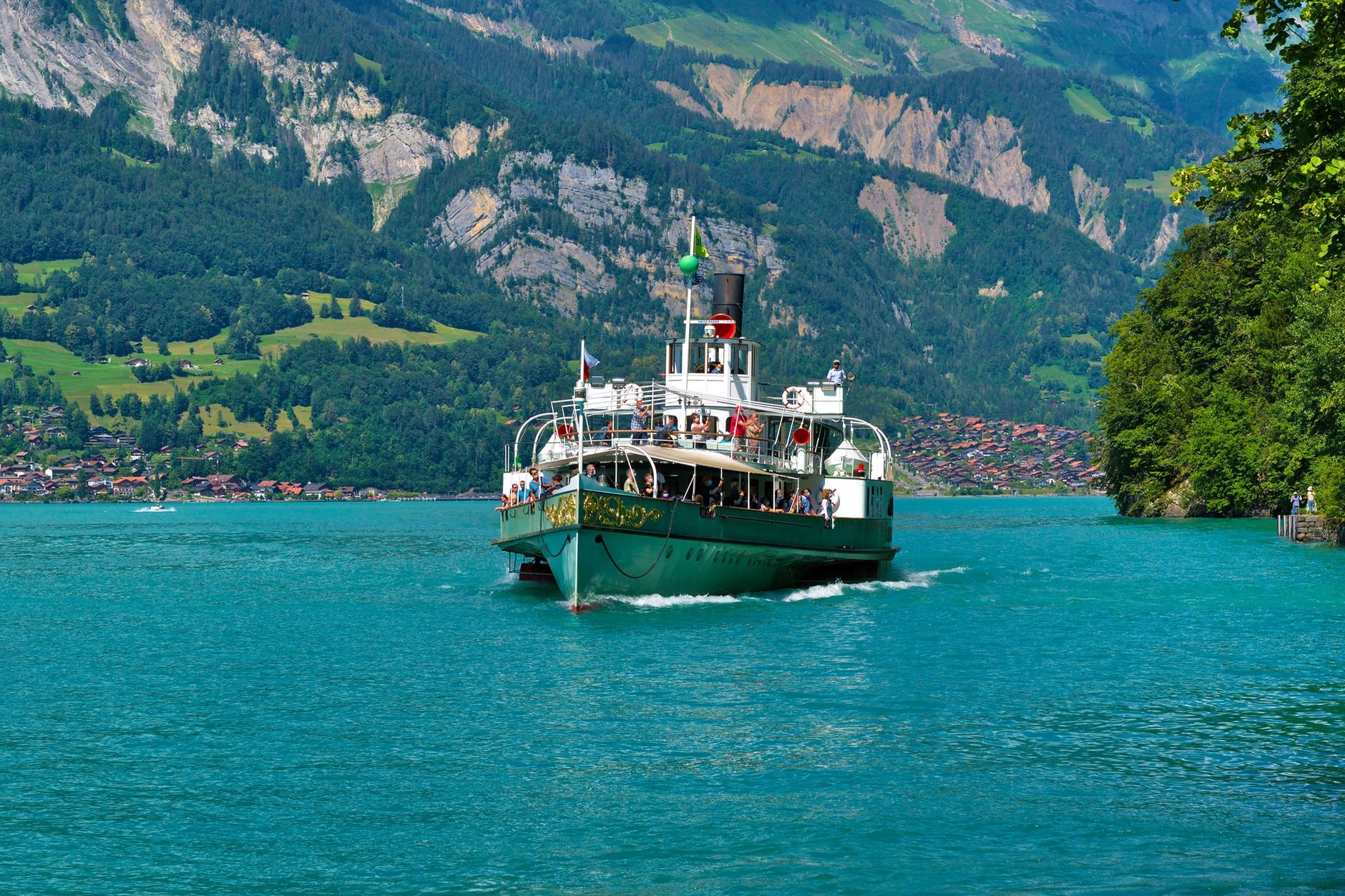 Historic paddle steamer boat cruising across turquoise glacial waters of Lake Brienz