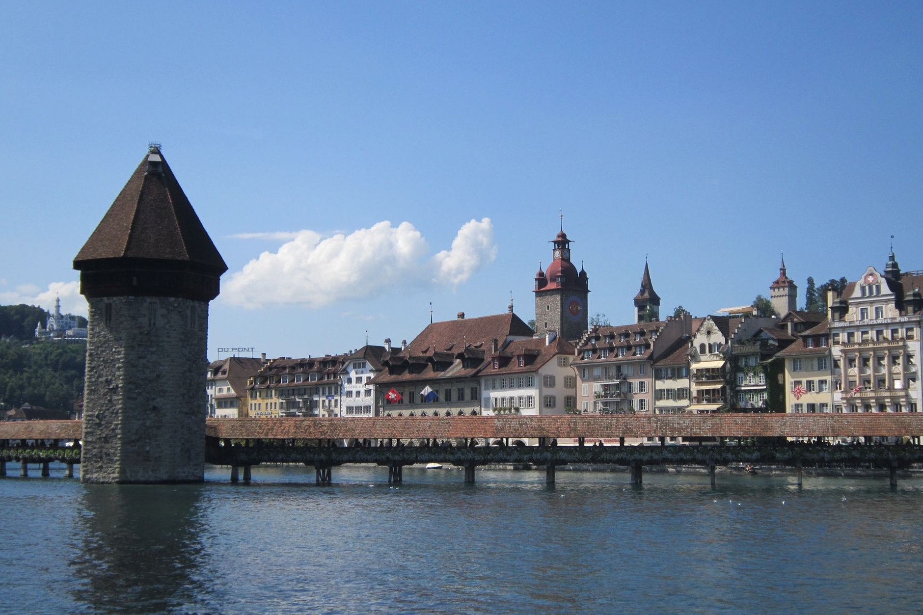 Historic covered wooden Chapel Bridge and octagonal water tower crossing the Reuss River in Lucerne