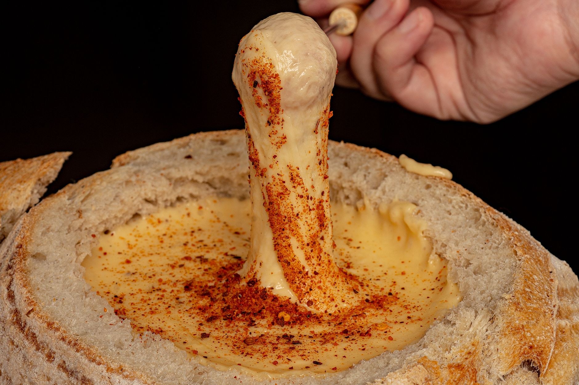 Cast-iron caquelon pot of bubbling melted Gruyère and Emmental cheese served with crusty bread cubes
