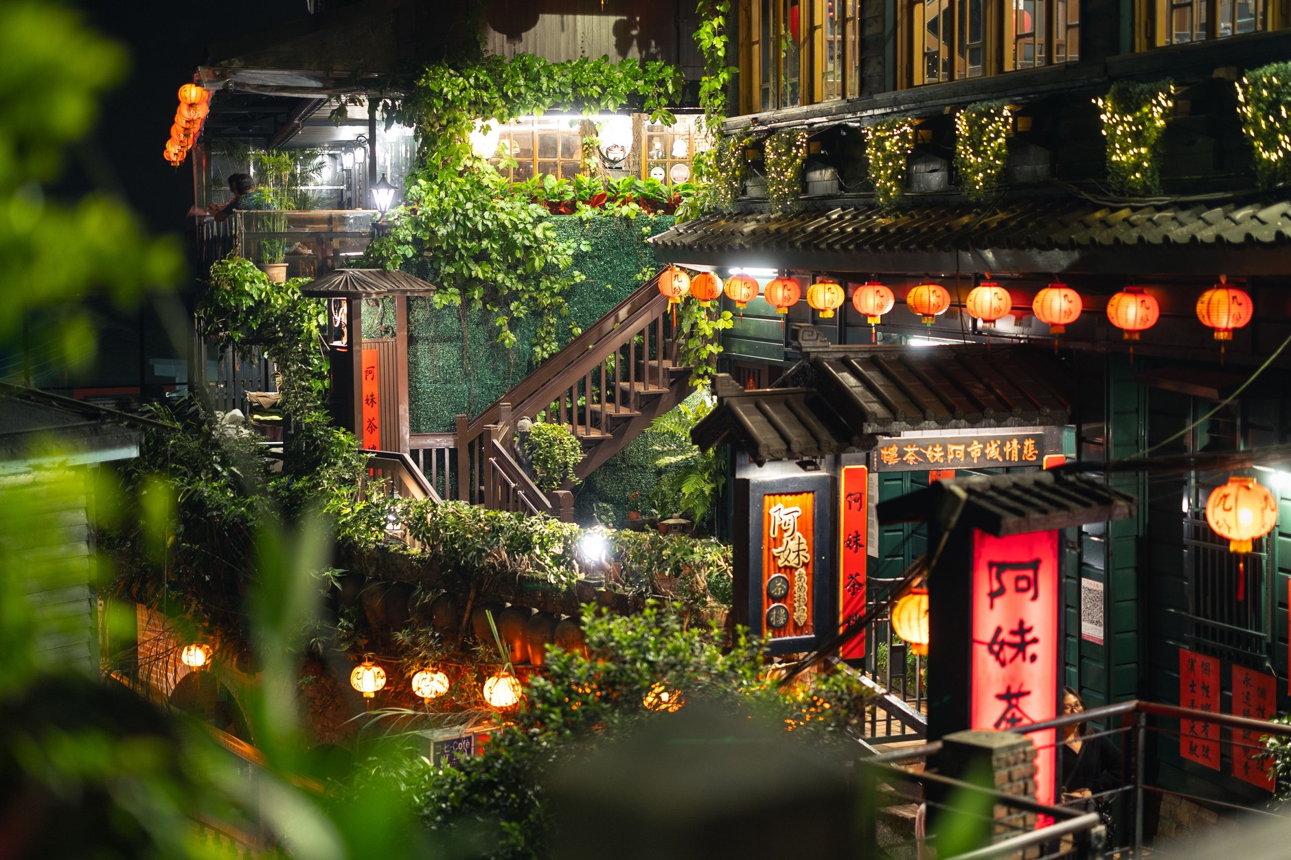 Red paper lanterns illuminating the steep cobblestone stairs of Jiufen Old Street