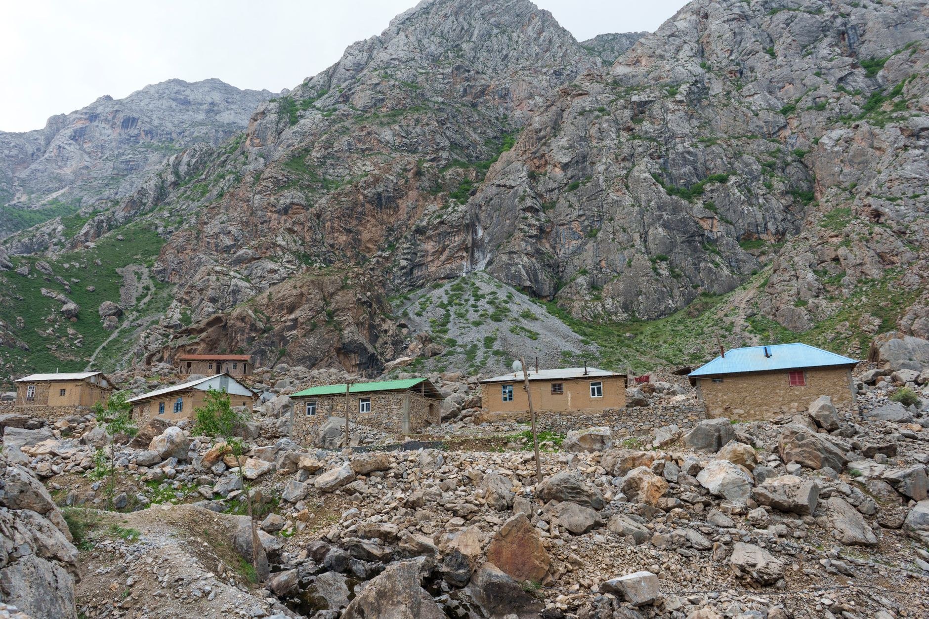 Rustic stone-and-mudbrick houses beside mountain streams with walnut trees beneath towering crags