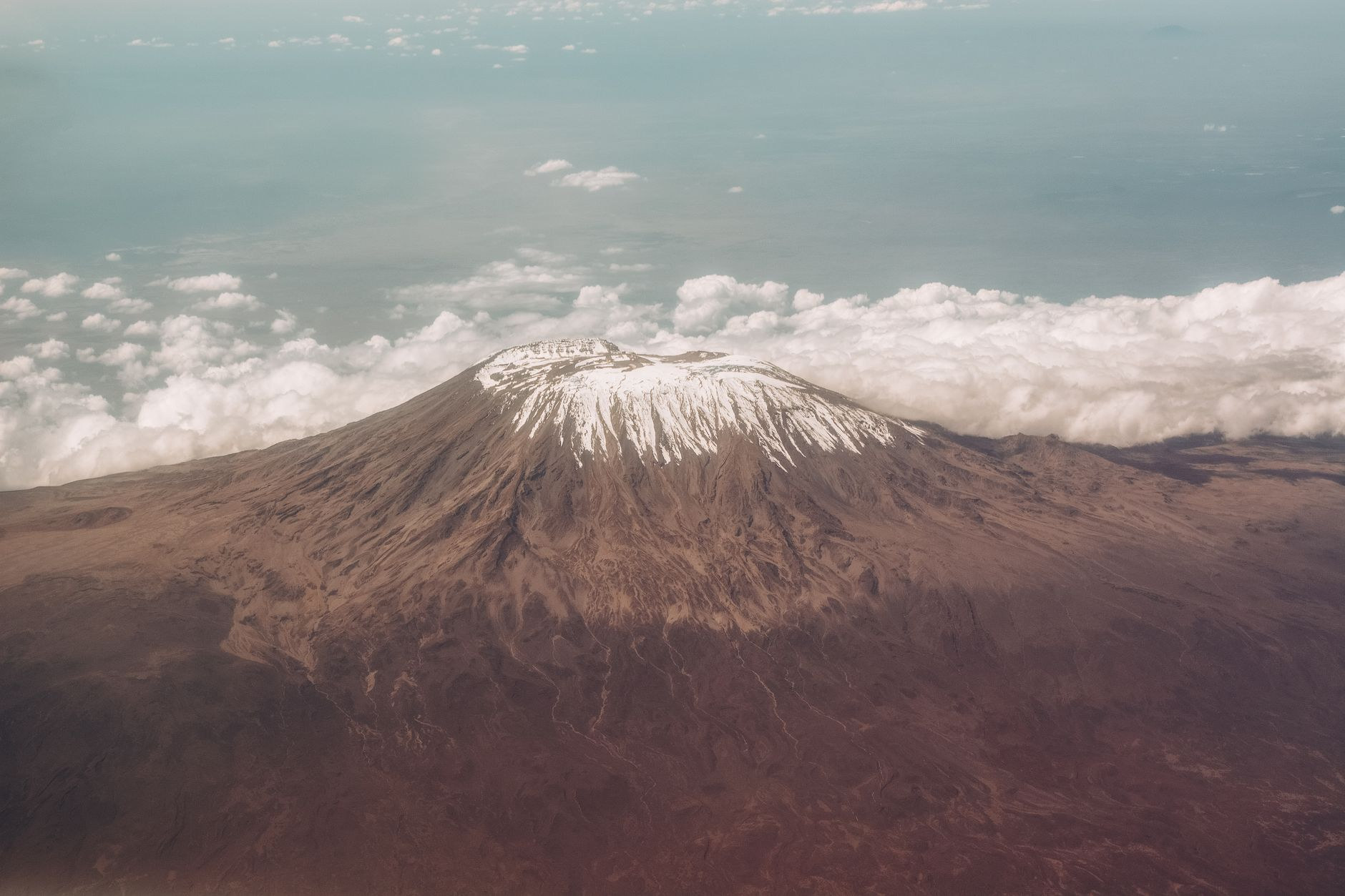 Snow-capped summit of Mount Kilimanjaro rising above the clouds