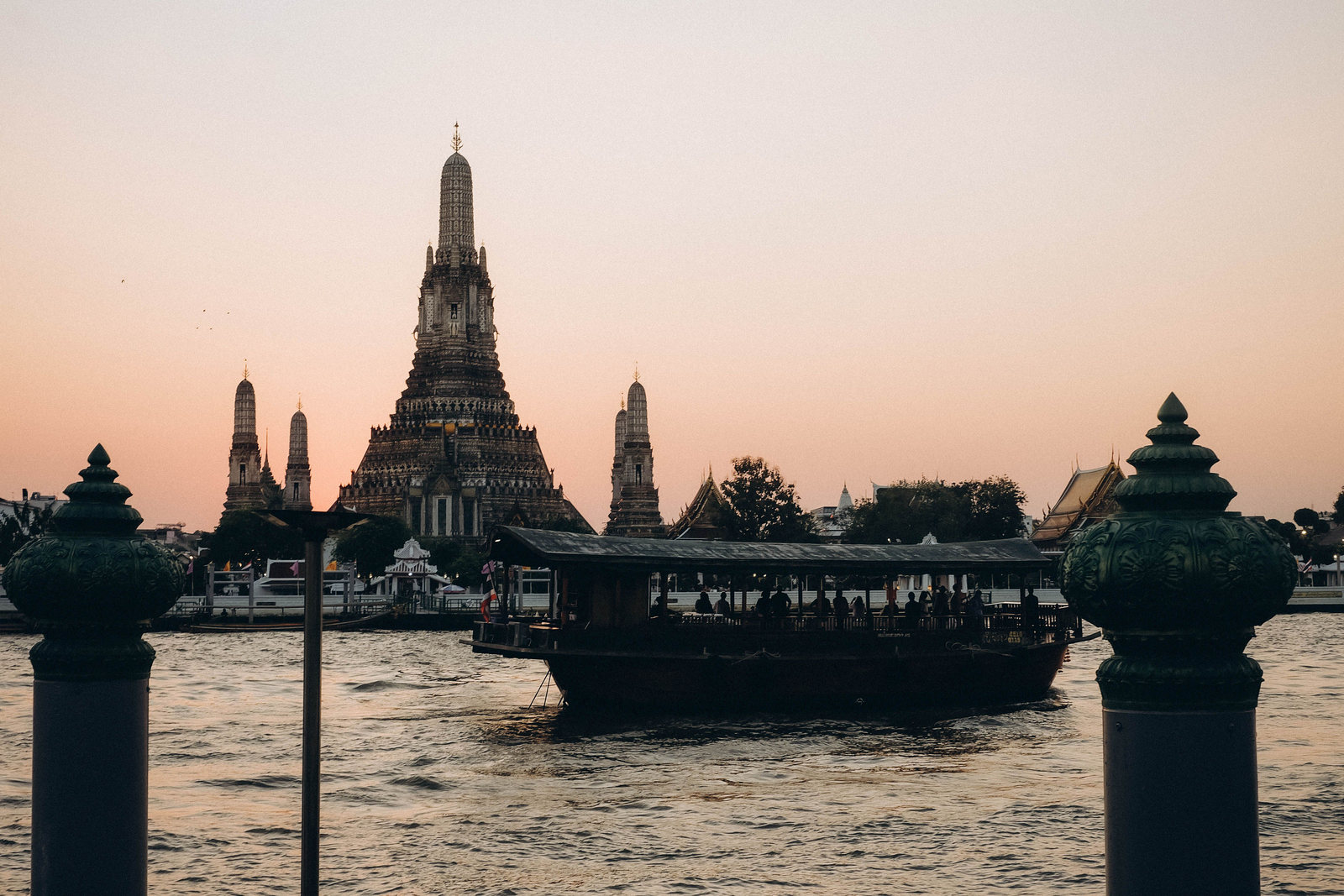Wat Arun temple across the Chao Phraya River at sunset in Bangkok