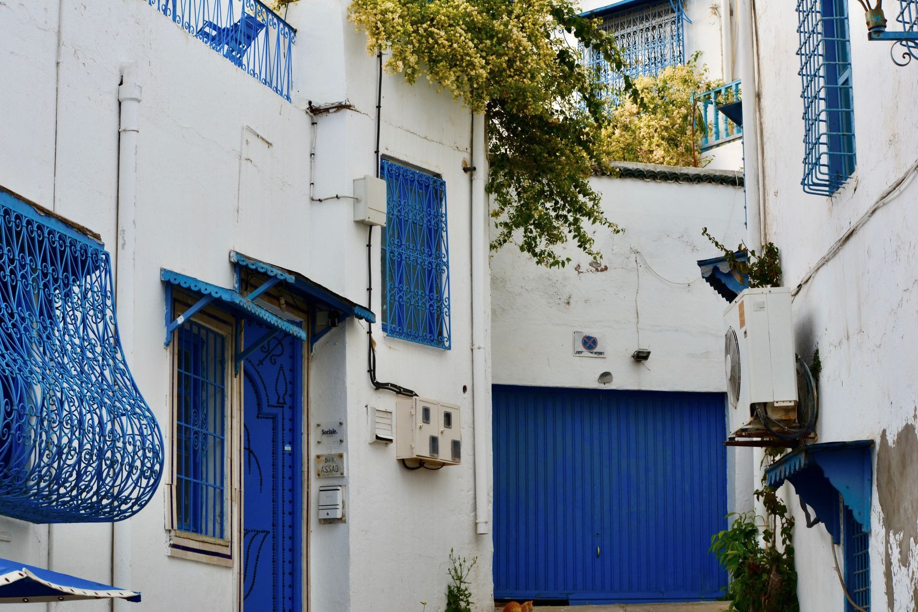 Historic cobblestone alleyway beneath stone horseshoe arches inside the UNESCO-listed Medina of Tunis