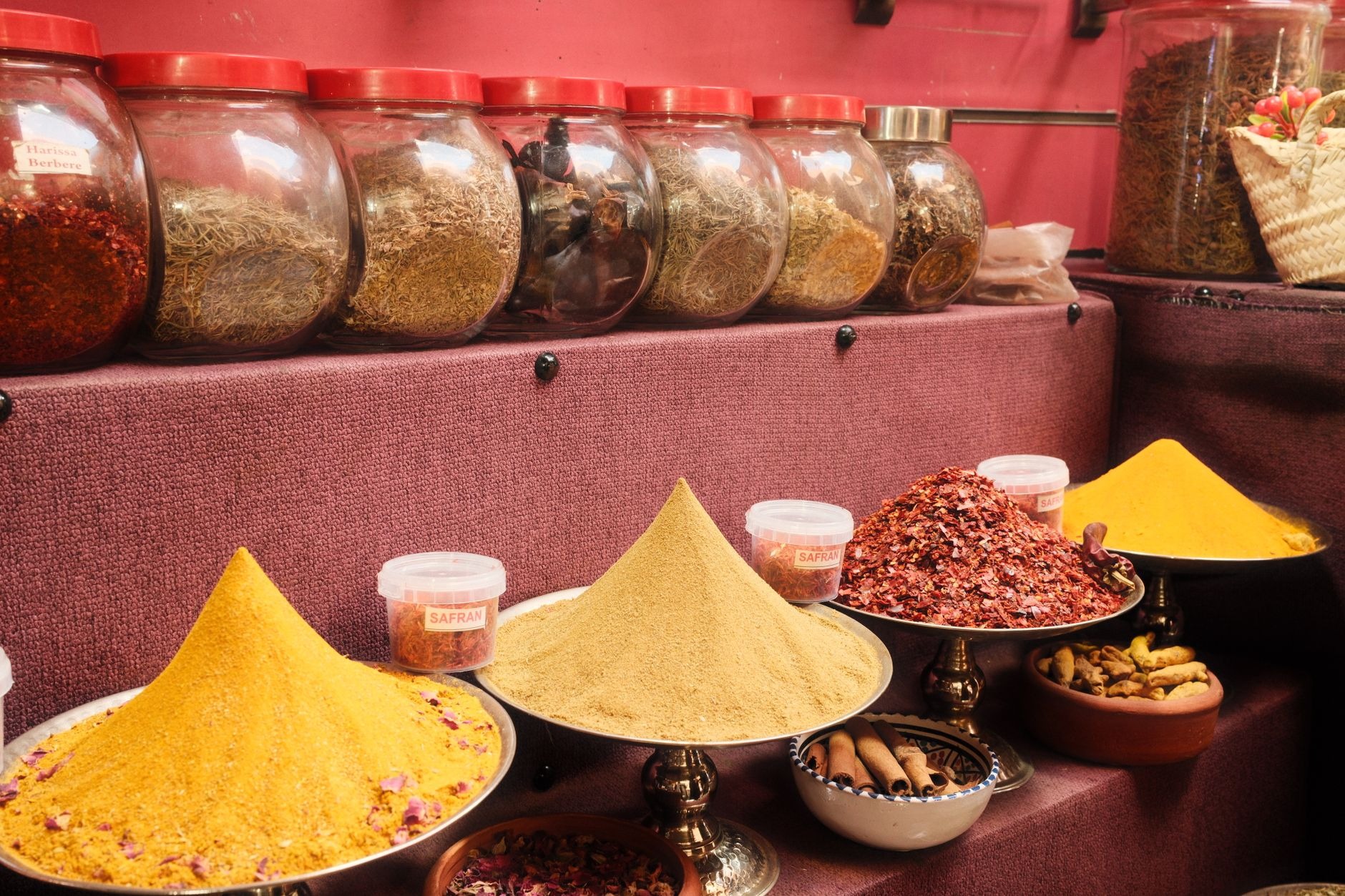 Pyramids of fragrant cumin, paprika, dried rose petals, and spicy dried peppers displayed in an authentic Tunisian spice souq