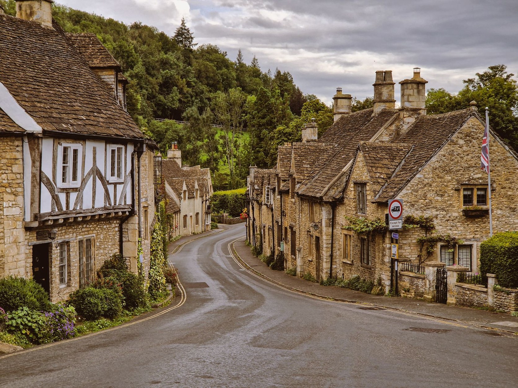 Historic honey-colored limestone cottages lining a quiet lane in the Cotswolds