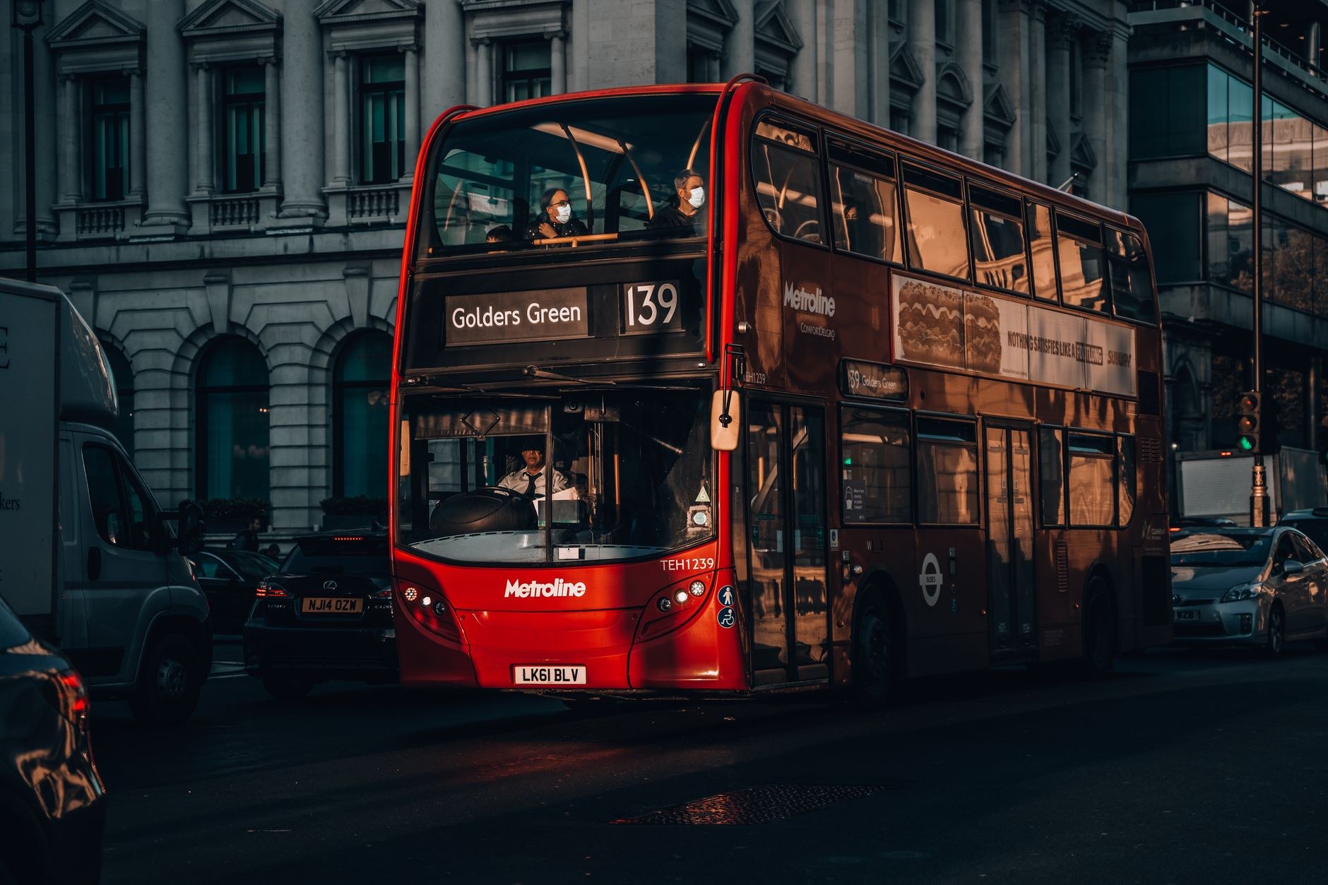 Classic red double-decker bus moving through historic London streets