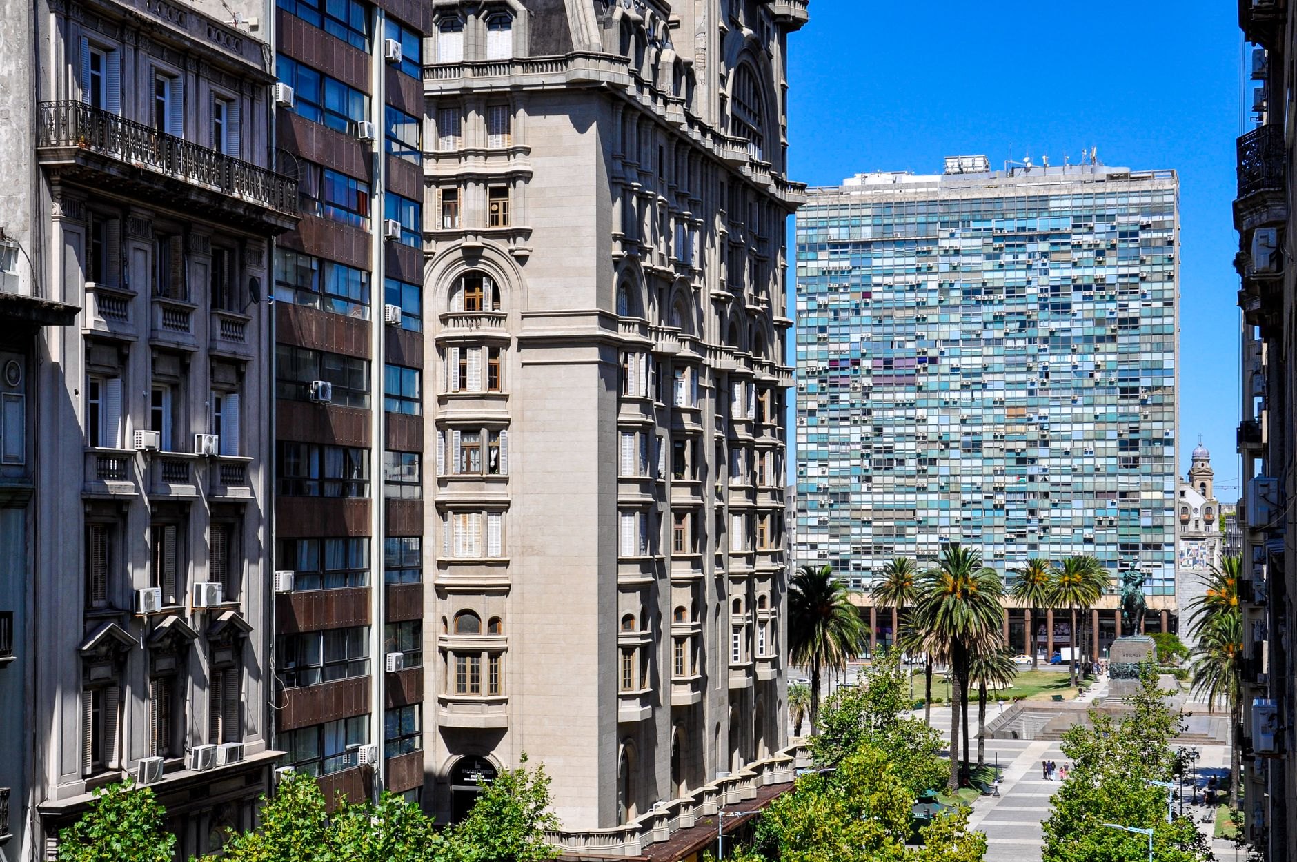 Eclectic towering 1920s architecture of Palacio Salvo presiding over palm trees on Plaza Independencia in Montevideo