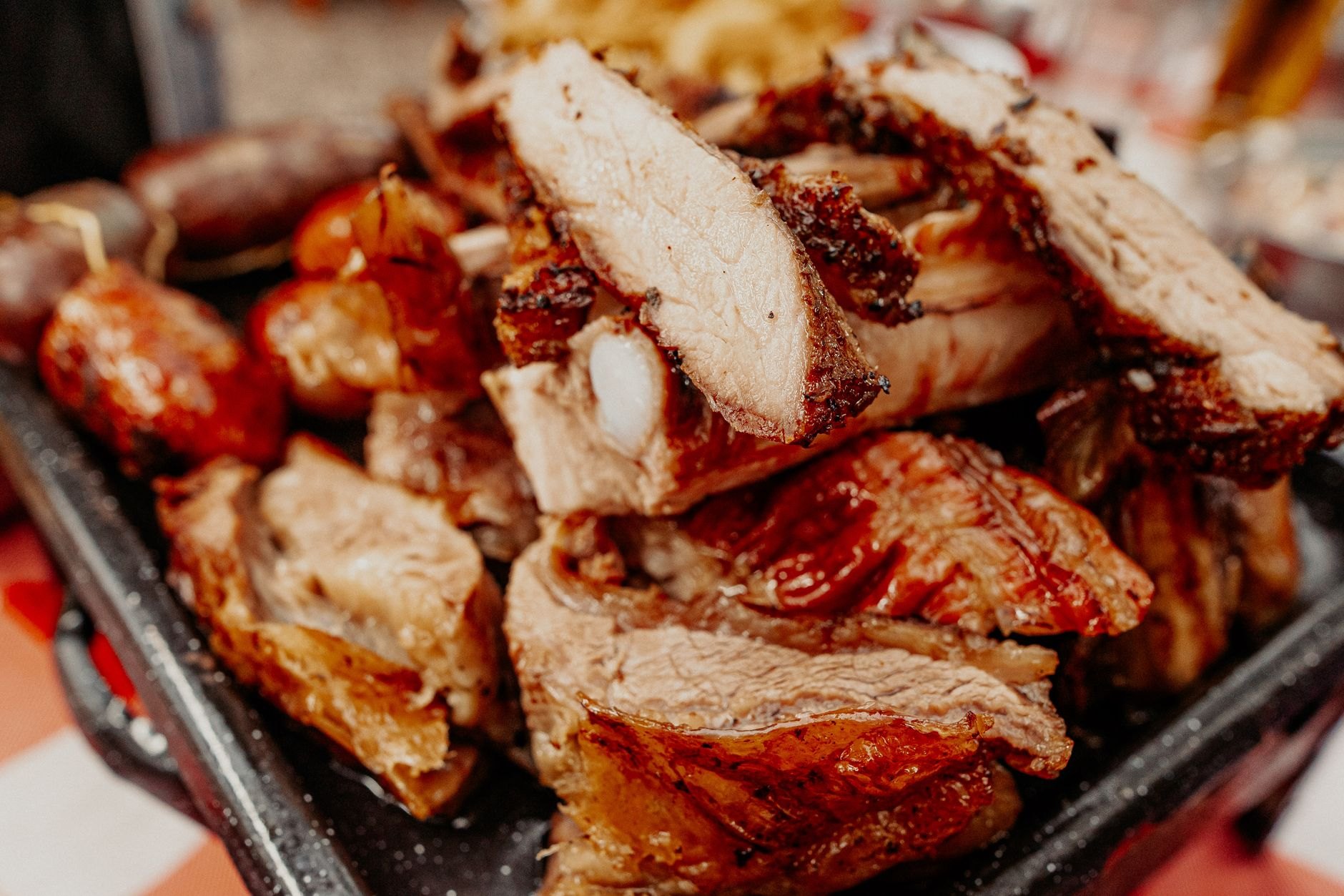 Prime cuts of beef ribs, chorizo sausages, and morcilla slow-roasting on an inclined iron parrilla over fragrant hardwood coals