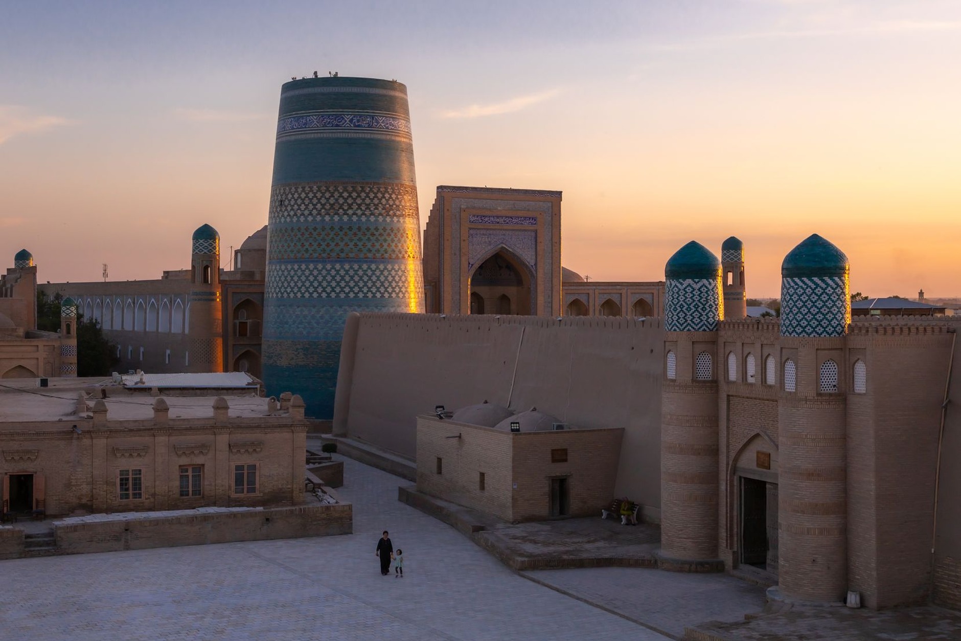 Iconic stout turquoise-glazed Kalta Minor minaret standing within the ancient mudbrick walls of Itchan Kala in Khiva