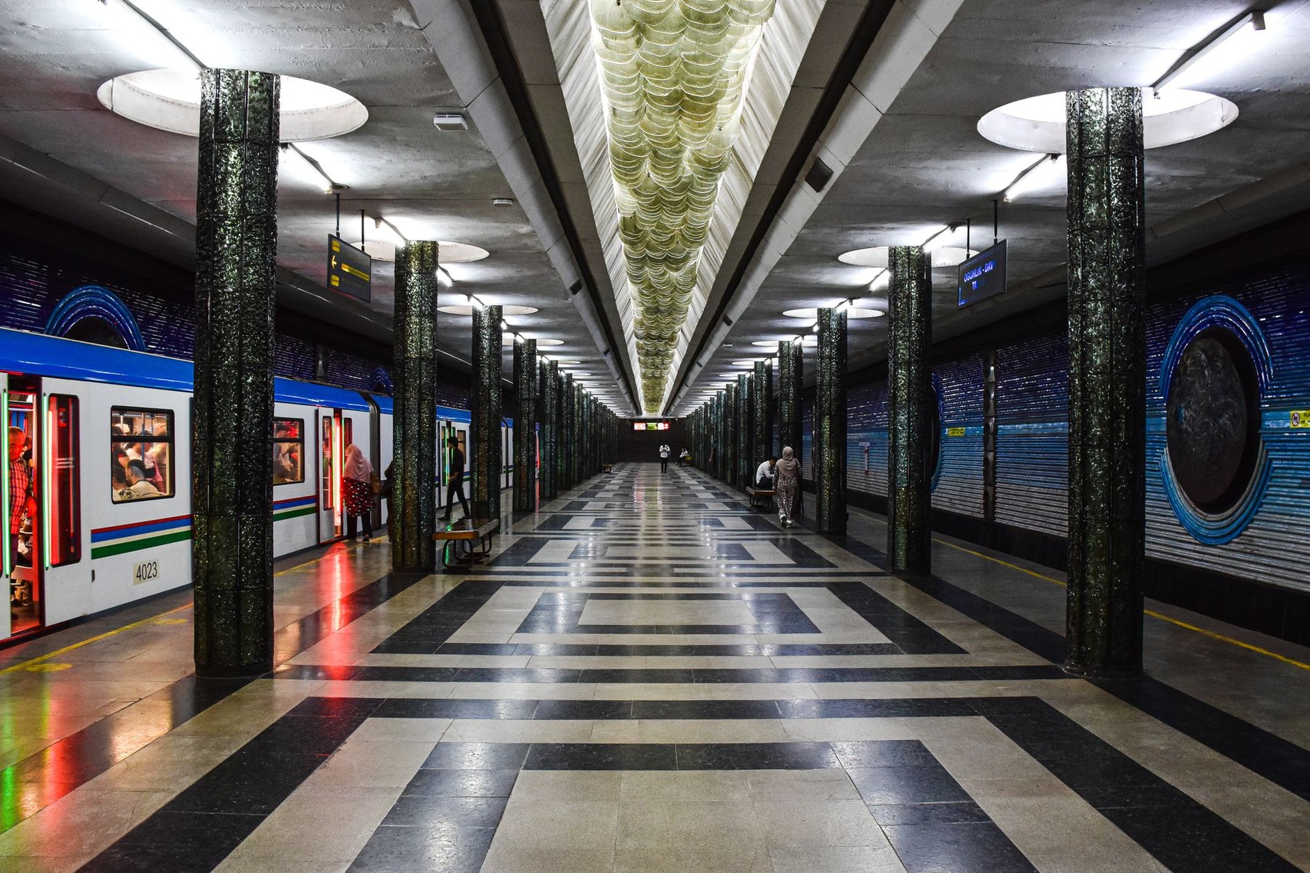 Ornate vaulted marble pillars and crystal chandeliers inside an underground transit hall of the Tashkent Metro in Uzbekistan