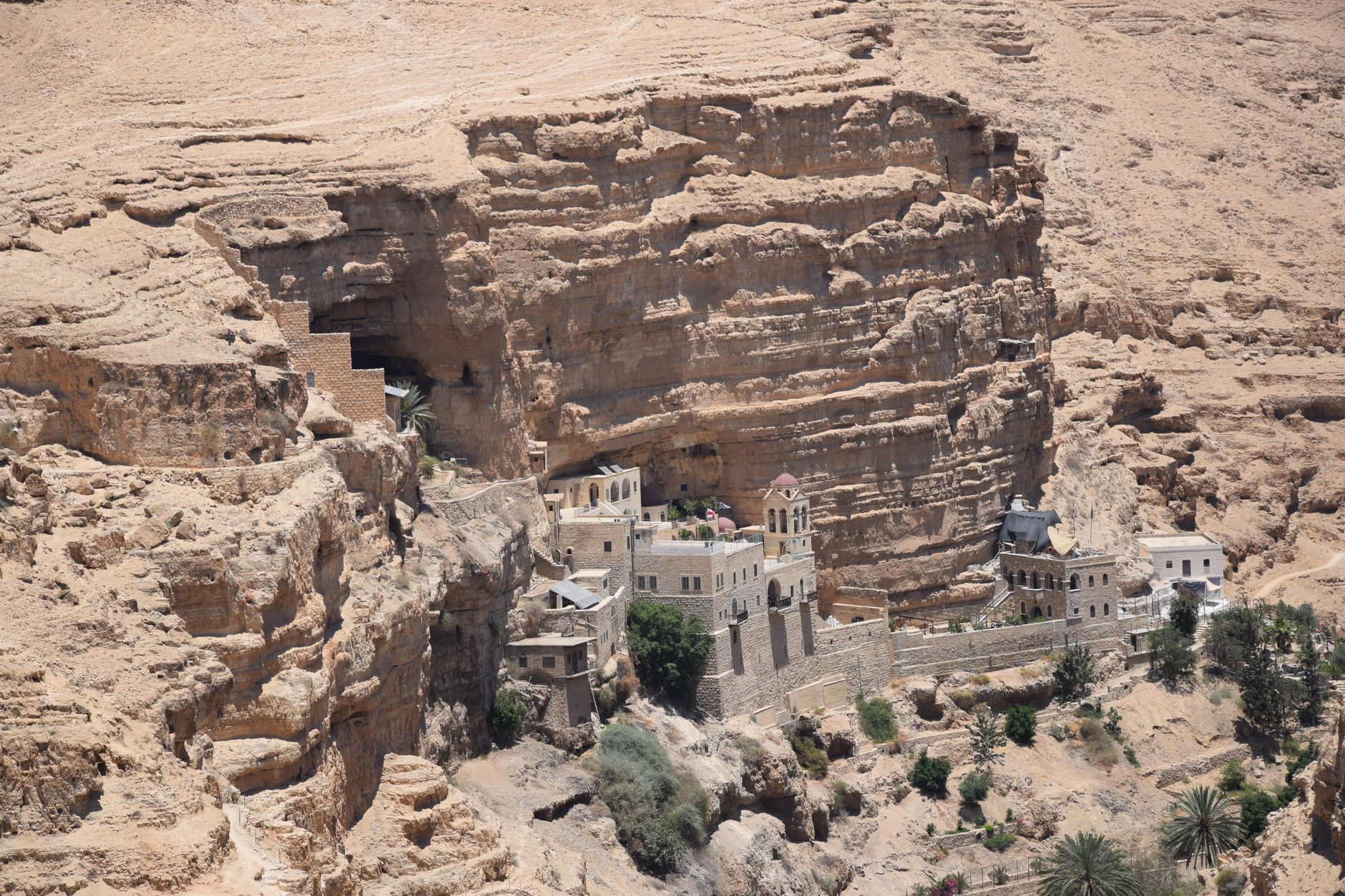 Ancient stone complex of Saint George's Monastery built into the sheer rock walls of Wadi Qelt