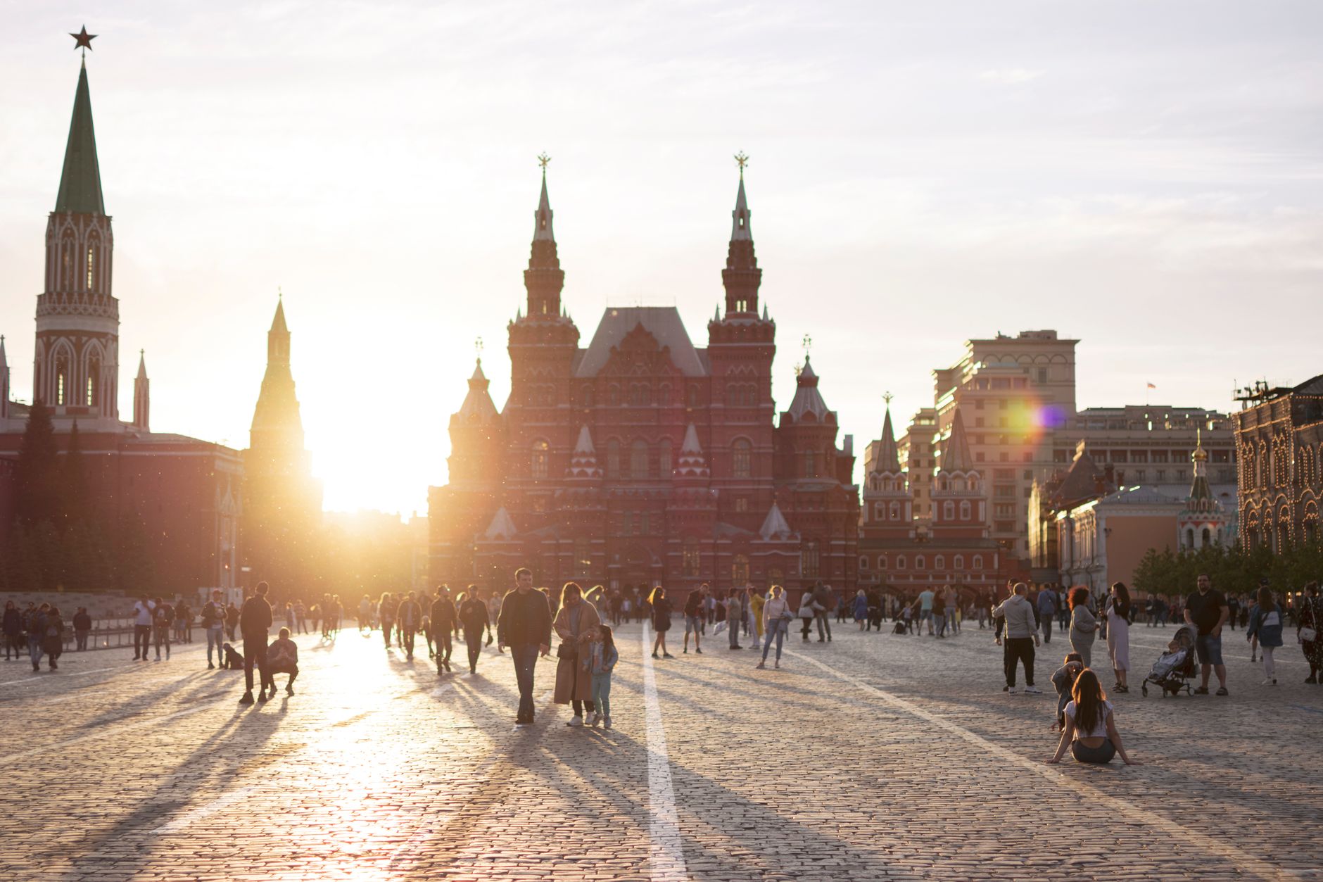 Pedestrians strolling across the historic cobblestones of Red Square in central Moscow at dusk