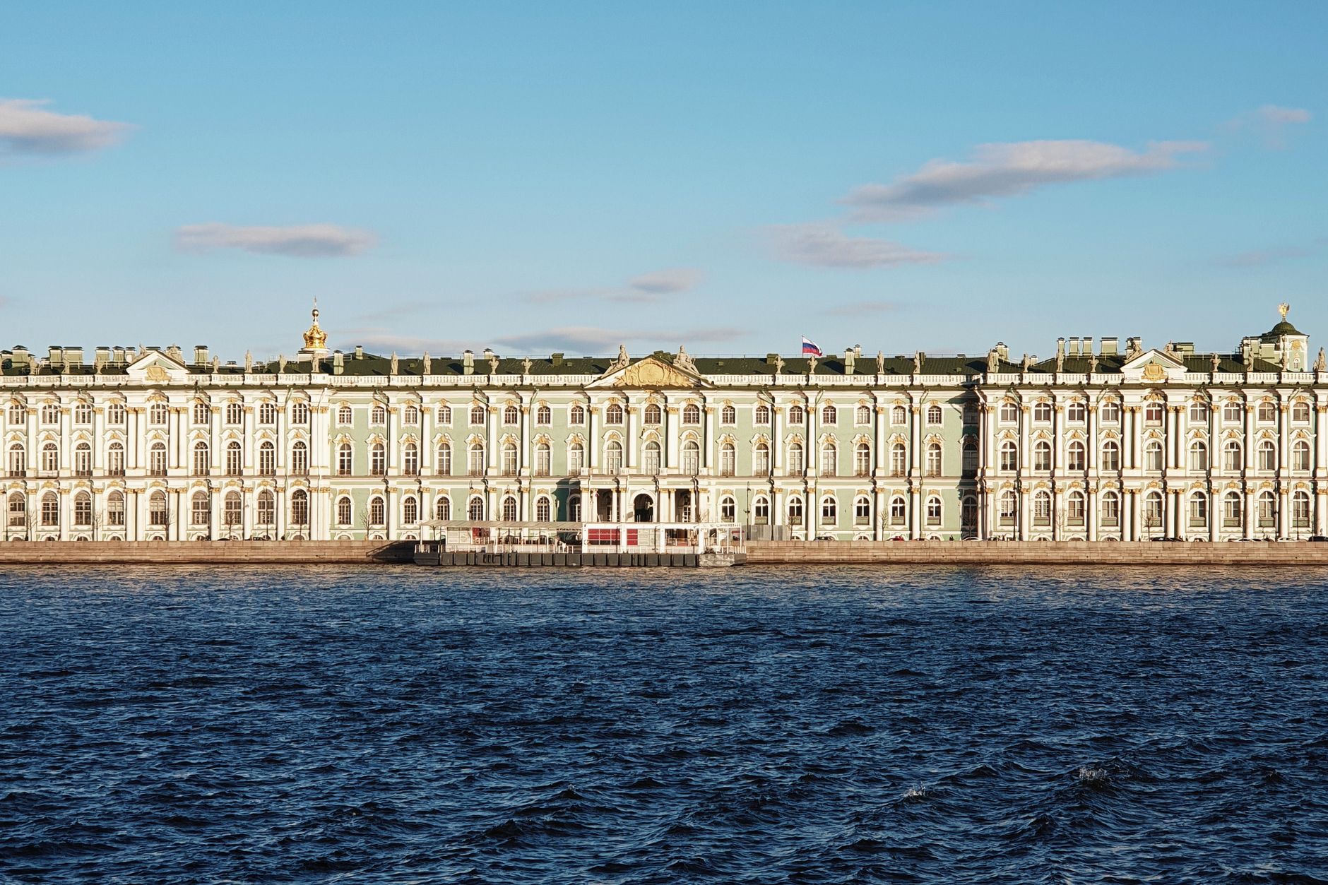 Baroque green and white facade of the Winter Palace and State Hermitage Museum along the Neva River
