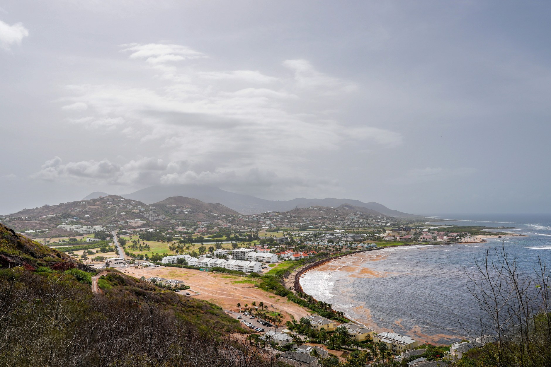 Aerial perspective of Saint Kitts emerald green headlands meeting the sapphire Caribbean Sea