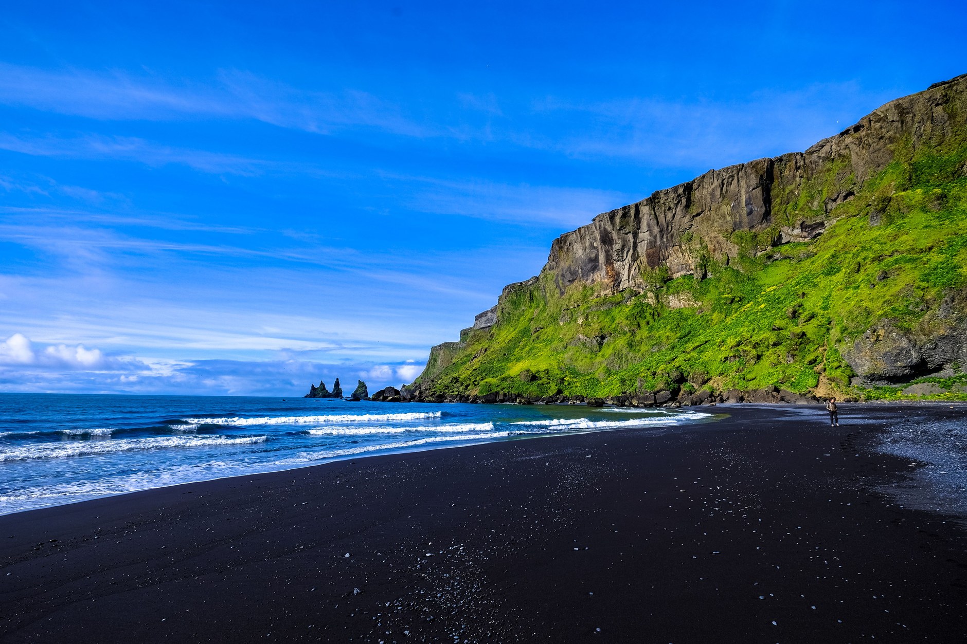 Volcanic black sand shoreline and dramatic emerald bluffs on Saint Vincent's leeward coast