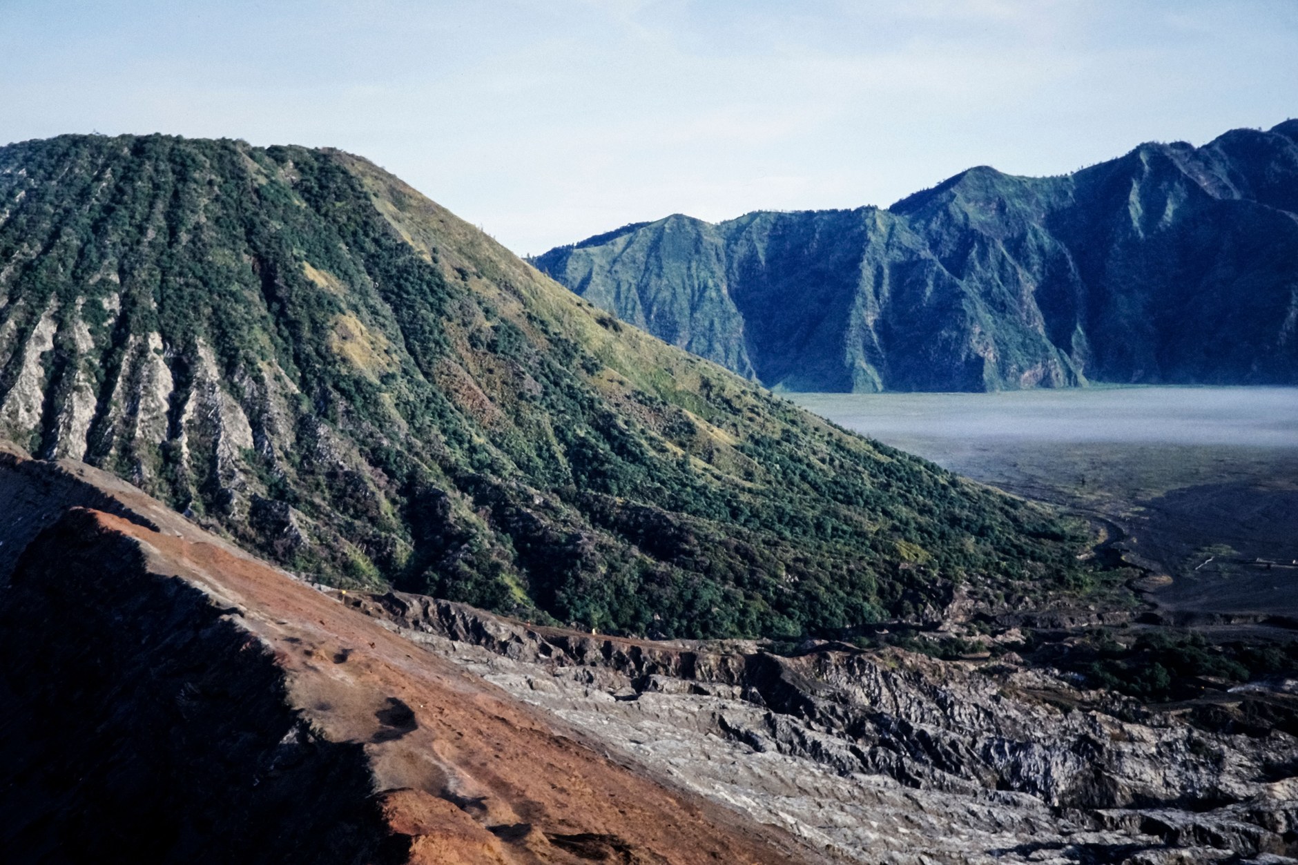 Rugged volcanic crater and lush green mountain ridge surrounding La Soufrière