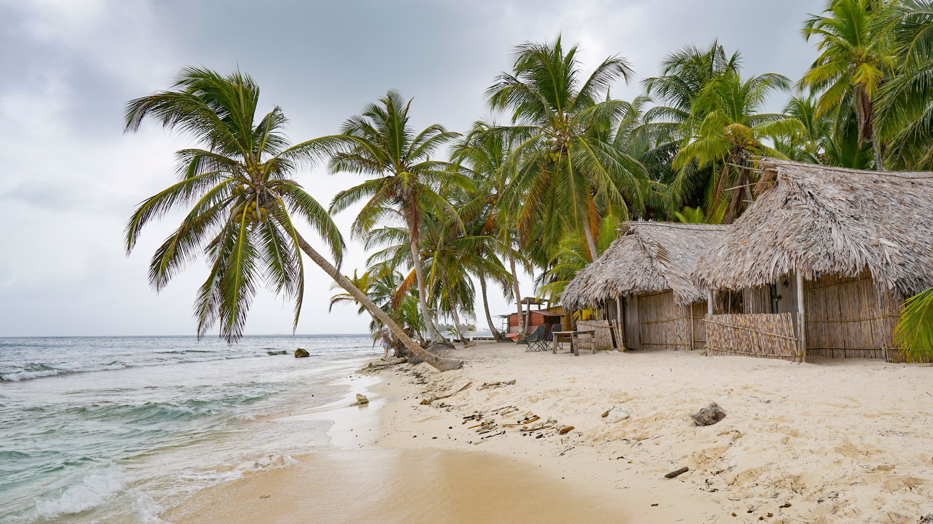 Traditional thatched roof wooden beach fales on the white coral sand of Lalomanu Beach