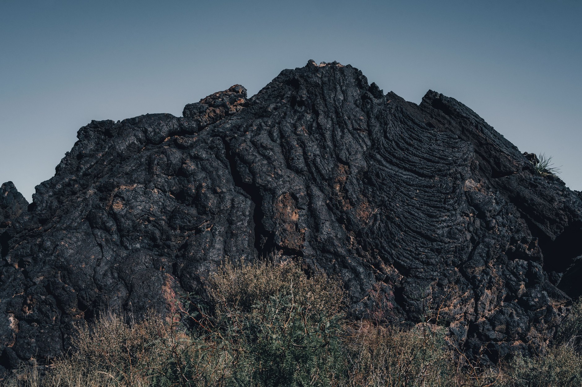 Black basalt lava fields surrounding the ruined stone church walls at Saleaula village