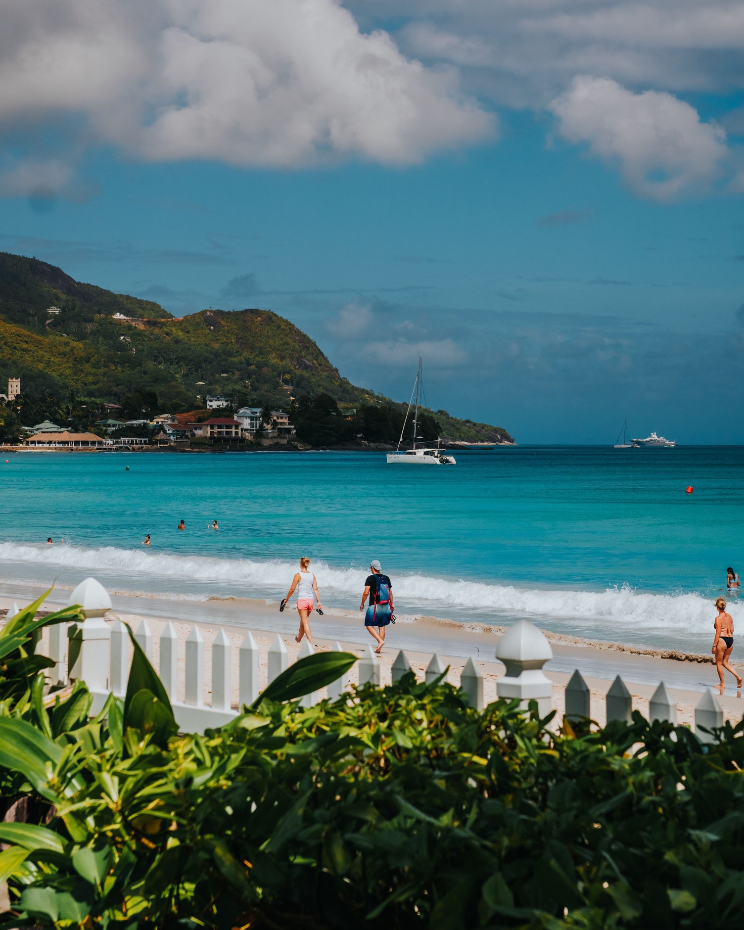 A wide sweeping curve of calm turquoise water and golden sand at Beau Vallon bay on northern Mahé